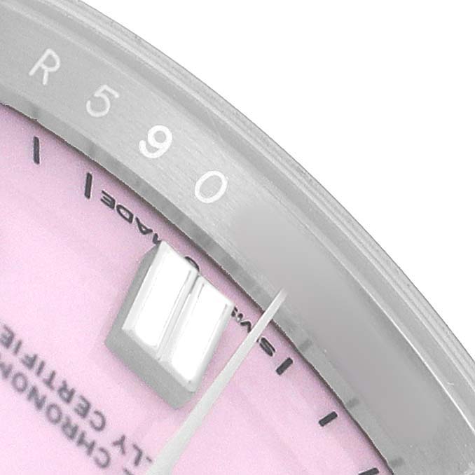The image shows a close-up of the dial and bezel of a Rolex Oyster Perpetual 126000 Men's Stainless Steel Pink Dial, highlighting the hour marker and text.