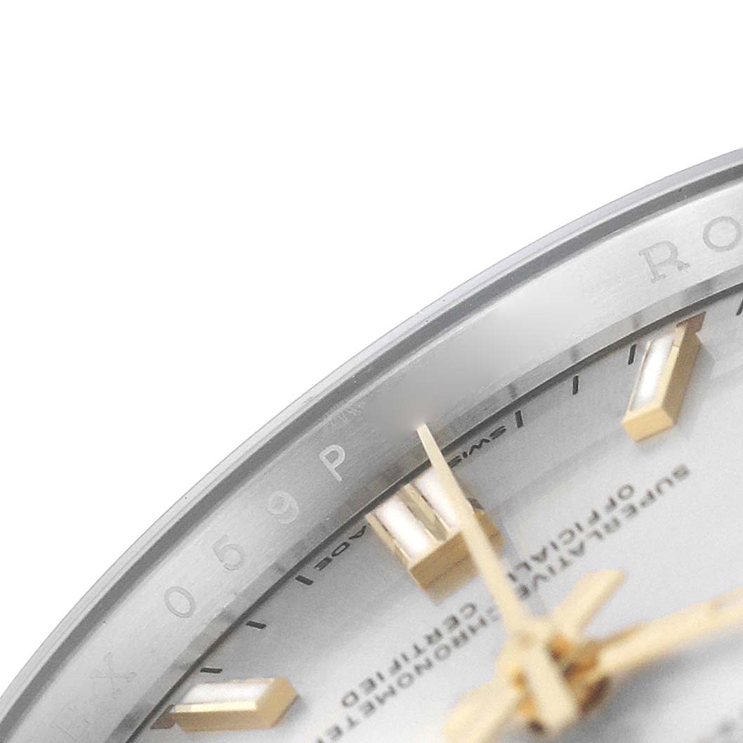 The image shows a close-up of the dial edge and hands of a Rolex Oyster Perpetual 126000 Men's Stainless Steel Silver Dial, focusing on the markers and text.