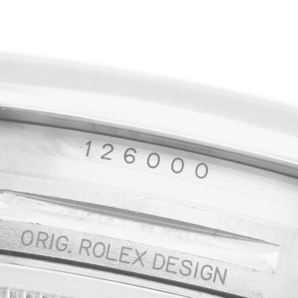The image shows a close-up of the case side of a Rolex Oyster Perpetual 126000 Men's Stainless Steel Silver Dial, highlighting the model number and "ORIG. ROLEX DESIGN" engraving.