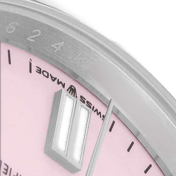 This close-up of a Rolex Oyster Perpetual 126000 Men's Stainless Steel Pink Dial watch shows part of the pink dial and hands, with "SWISS MADE" near the edge.