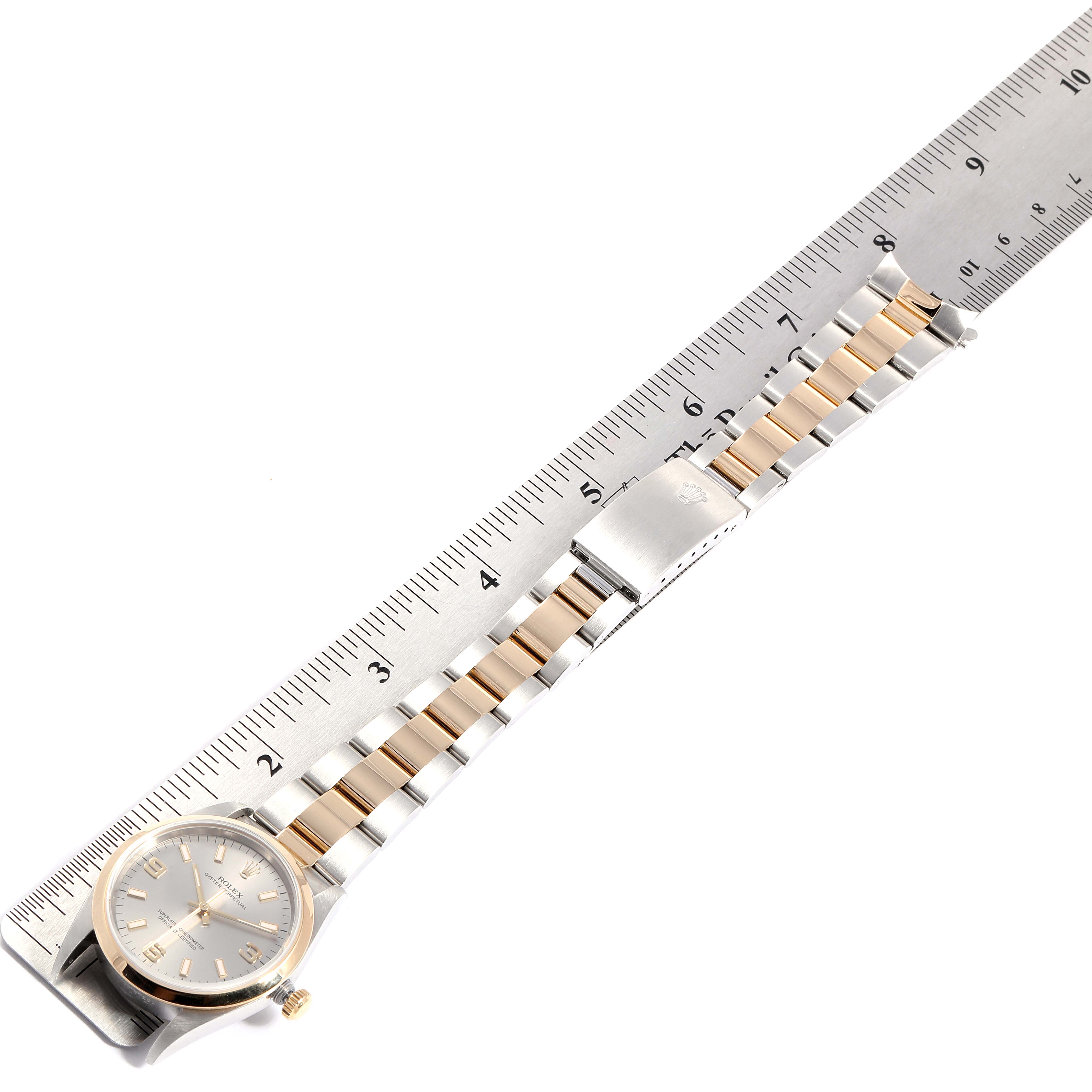 This image shows a side view of a Rolex Oyster Perpetual 14203 Men's Steel and Gold (two tone) Grey Dial 14203 Men's Steel and Gold (two tone) Grey Dial watch, including its bracelet and clasp, with a ruler for scale.