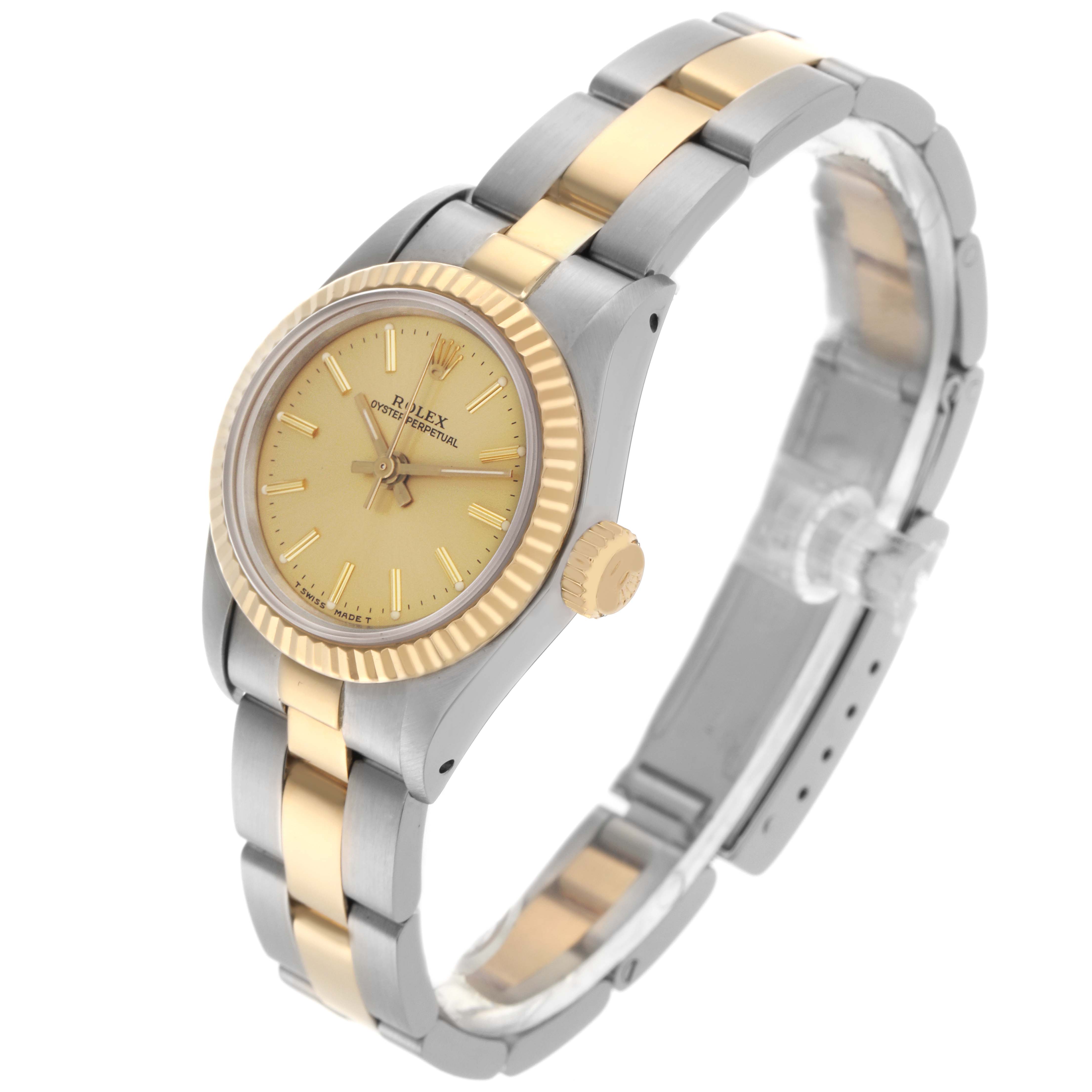 The Rolex Oyster Perpetual 67193 Women
s Steel and Gold (two tone) Champagne Dial 67193 Women
s Steel and Gold (two tone) Champagne Dial watch is shown at an angled side view, displaying its gold face, fluted bezel, crown, and two-tone bracelet.