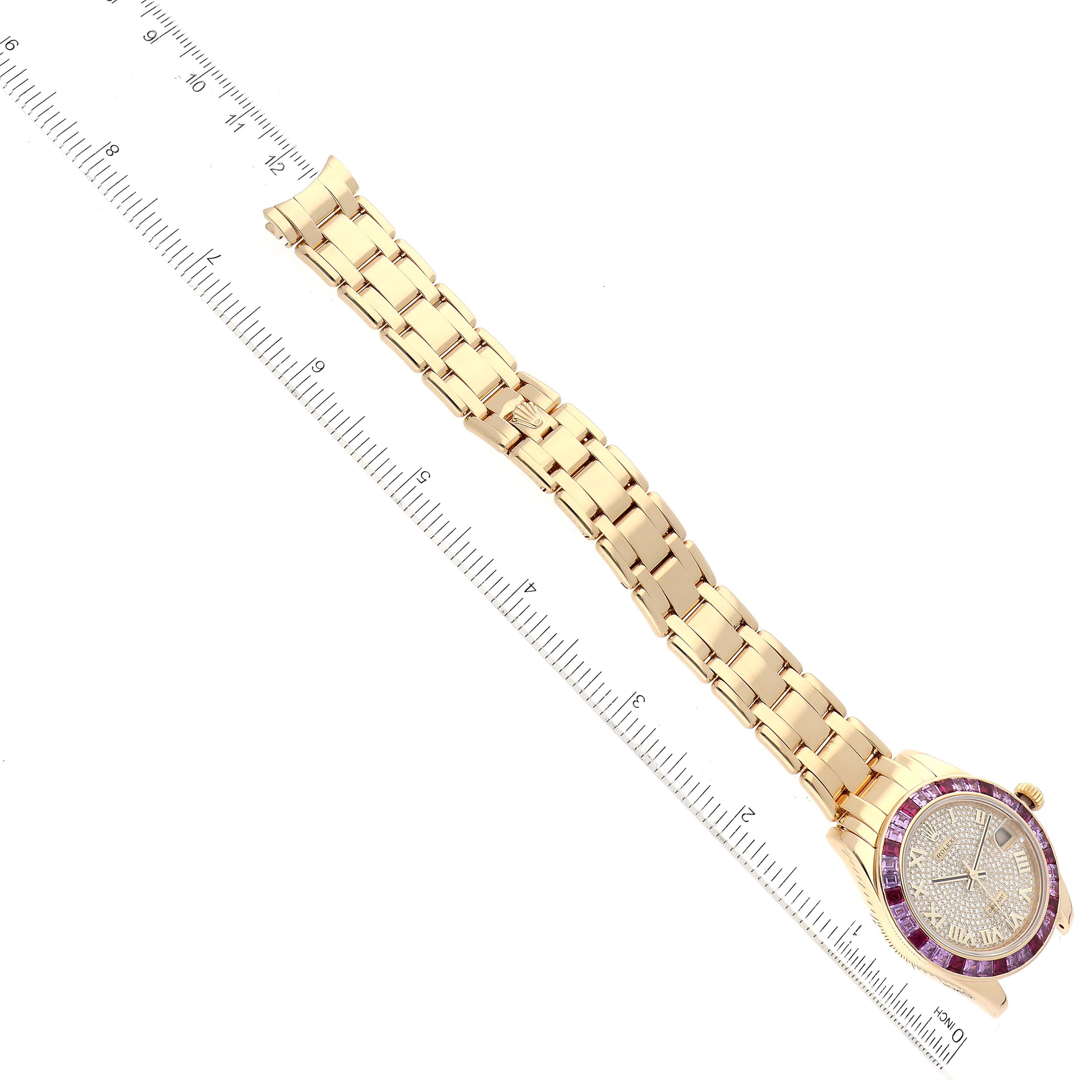 The Rolex Pearlmaster 81348SARO Women's Yellow Gold Champagne Dial 81348SARO Women's Yellow Gold Champagne Dial watch is shown from a top-down angle, displaying the full bracelet and face along with a measuring ruler.