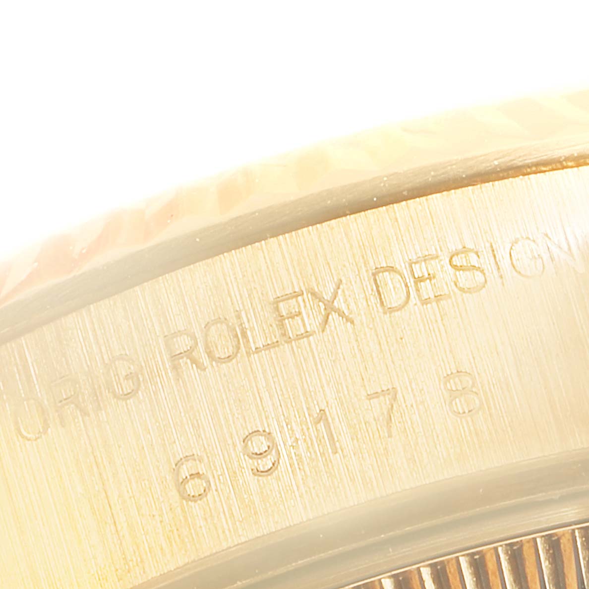 The image focuses on the side of the Rolex President 69178 Women
s Yellow Gold Champagne Dial 69178 Women
s Yellow Gold Champagne Dial model, showing the engraving and part of the fluted bezel.