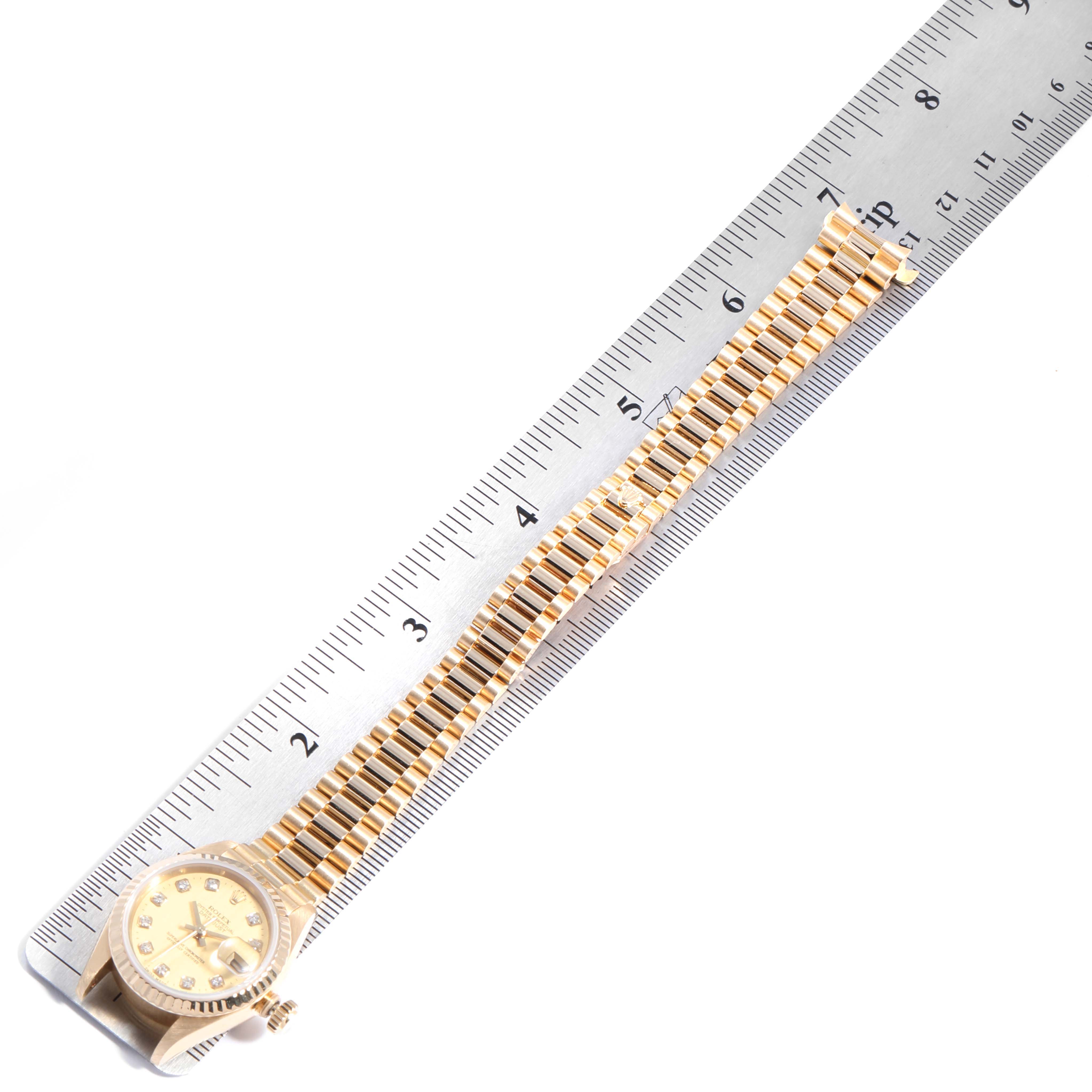 The Rolex President 69178 Women
s Yellow Gold Champagne Dial 69178 Women
s Yellow Gold Champagne Dial model watch is laid flat with its band displayed alongside a ruler for measurement.