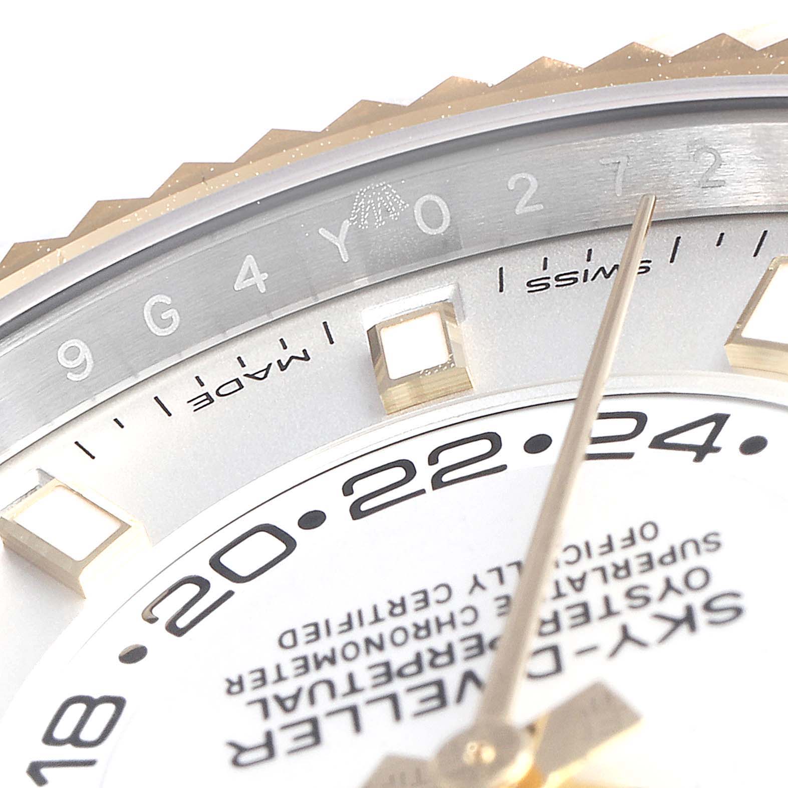 This close-up angle shows the dial, hour markers, and part of the bezel with engravings of the Rolex Sky-Dweller 326933 Men's Steel and Gold (two tone) White Dial 326933 Men's Steel and Gold (two tone) White Dial watch.