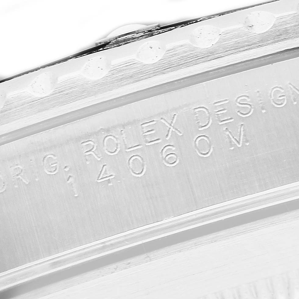 The image shows an angled close-up of the engraving on the case of a Rolex Submariner 14060 Men's Stainless Steel Black Dial.