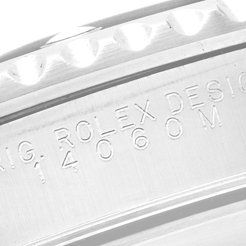 The image shows a close-up of the case side of a Rolex Submariner 14060M Men
s Stainless Steel Black Dial 14060M Men
s Stainless Steel Black Dial, with engraved model details.