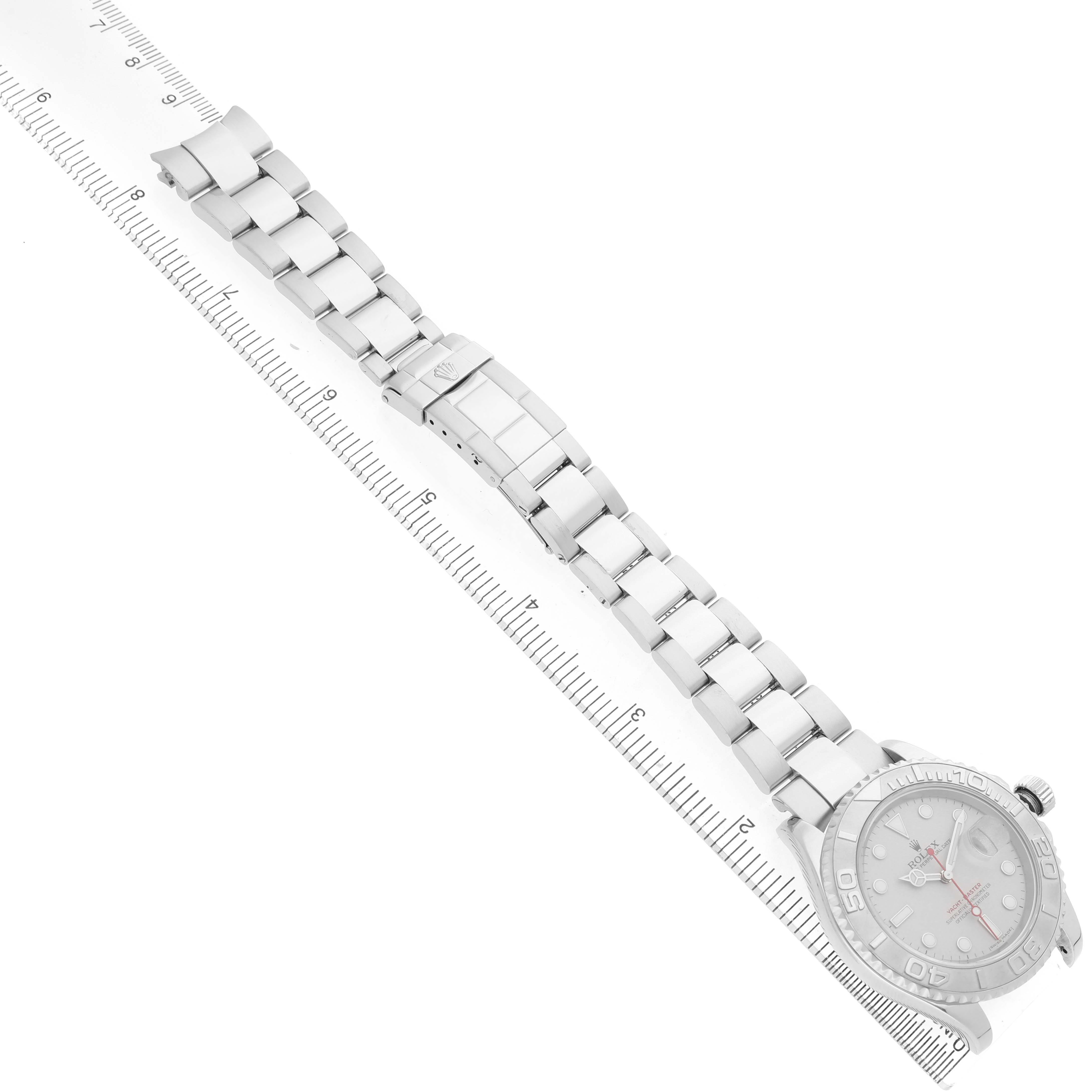 The Rolex Yacht-Master 16622 Men's Stainless Steel Silver Dial watch is shown at an angle, displaying the face, bracelet, and clasp, alongside a ruler for scale.