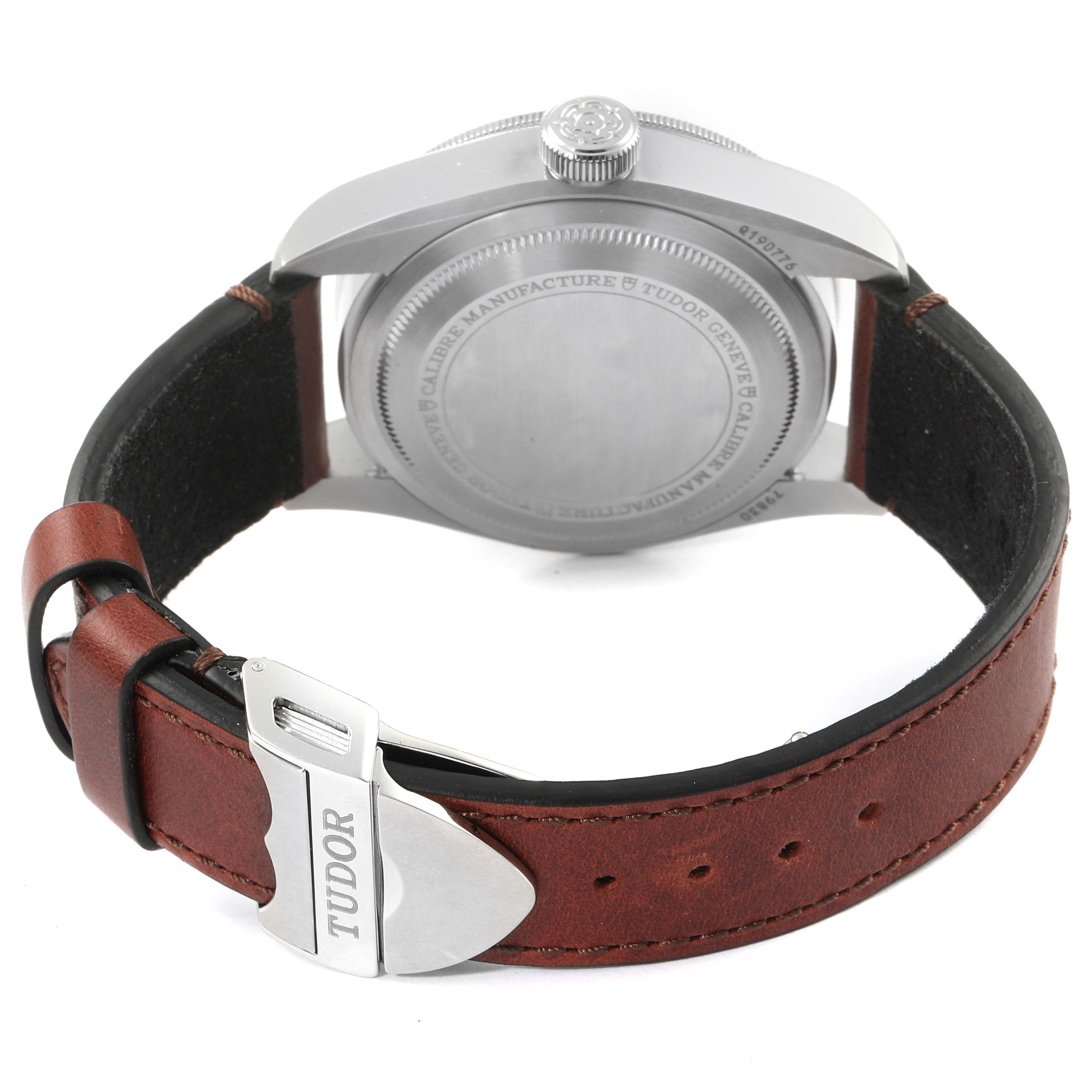 The image shows the back of the Tudor Heritage Black Bay 79830RB Men
s Stainless Steel Black Dial 79830RB Men
s Stainless Steel Black Dial watch, highlighting its case back and the leather strap with the Tudor clasp.