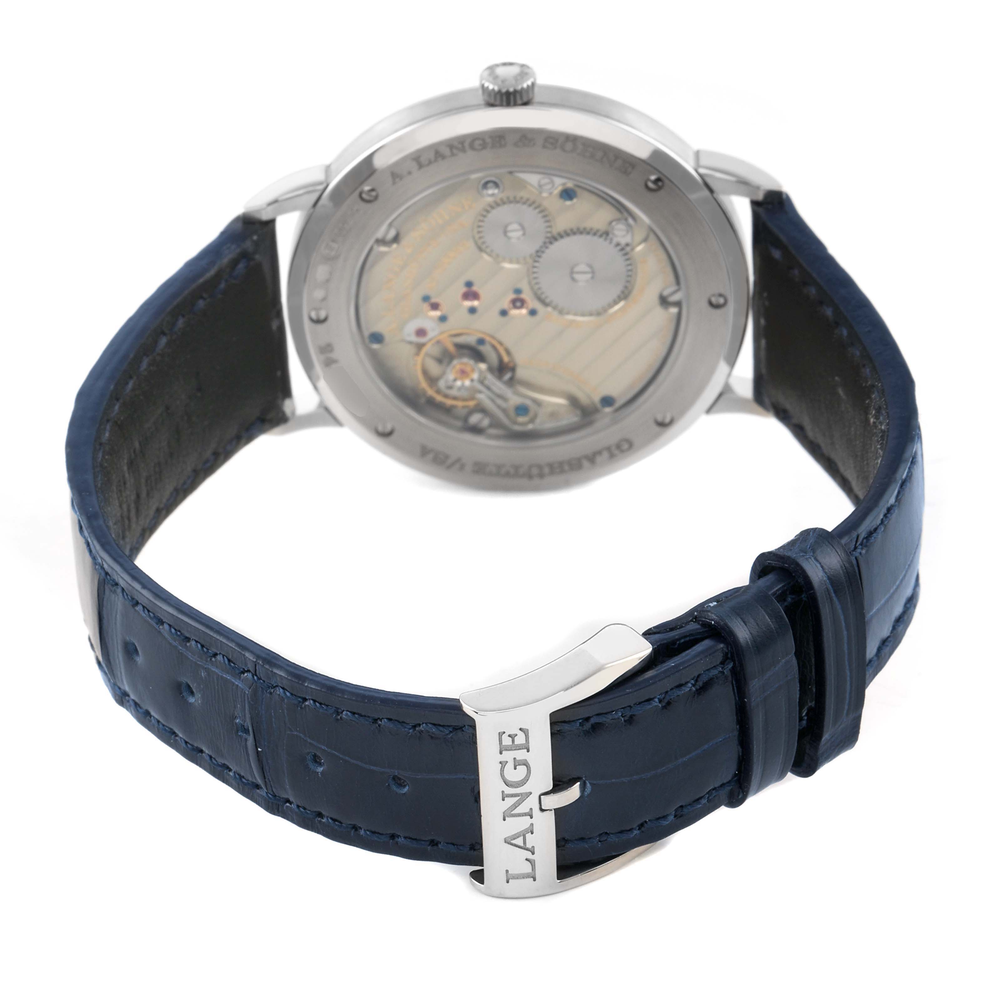 The image shows the back of the A. Lange & Sohne Saxonia 205.086 Men's White Gold Blue Dial watch, highlighting the movement and a blue leather strap with the "LANGE" buckle.