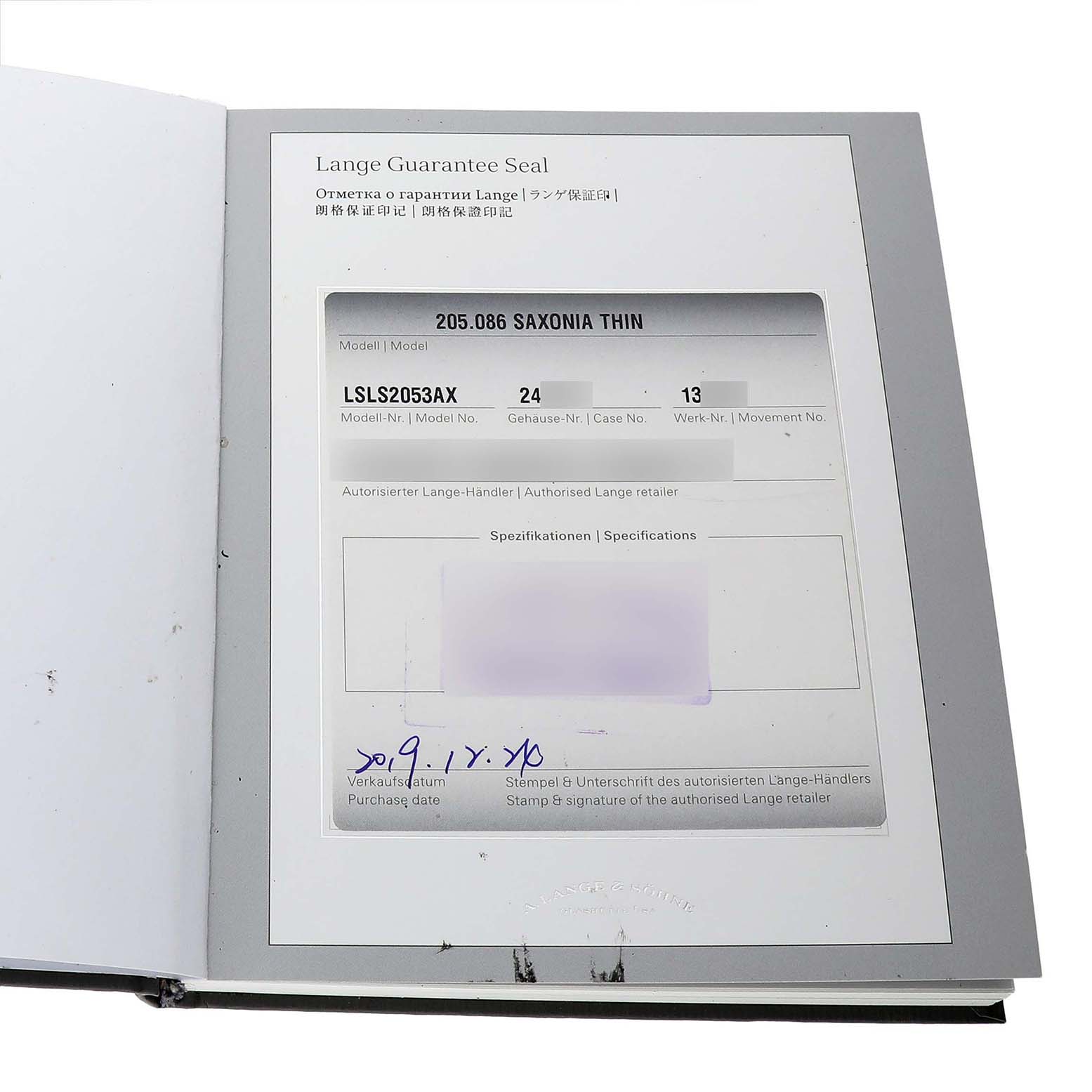 The image shows an open warranty booklet for the A. Lange & Sohne Saxonia 205.086 Men's White Gold Blue Dial model, displaying model and case information.