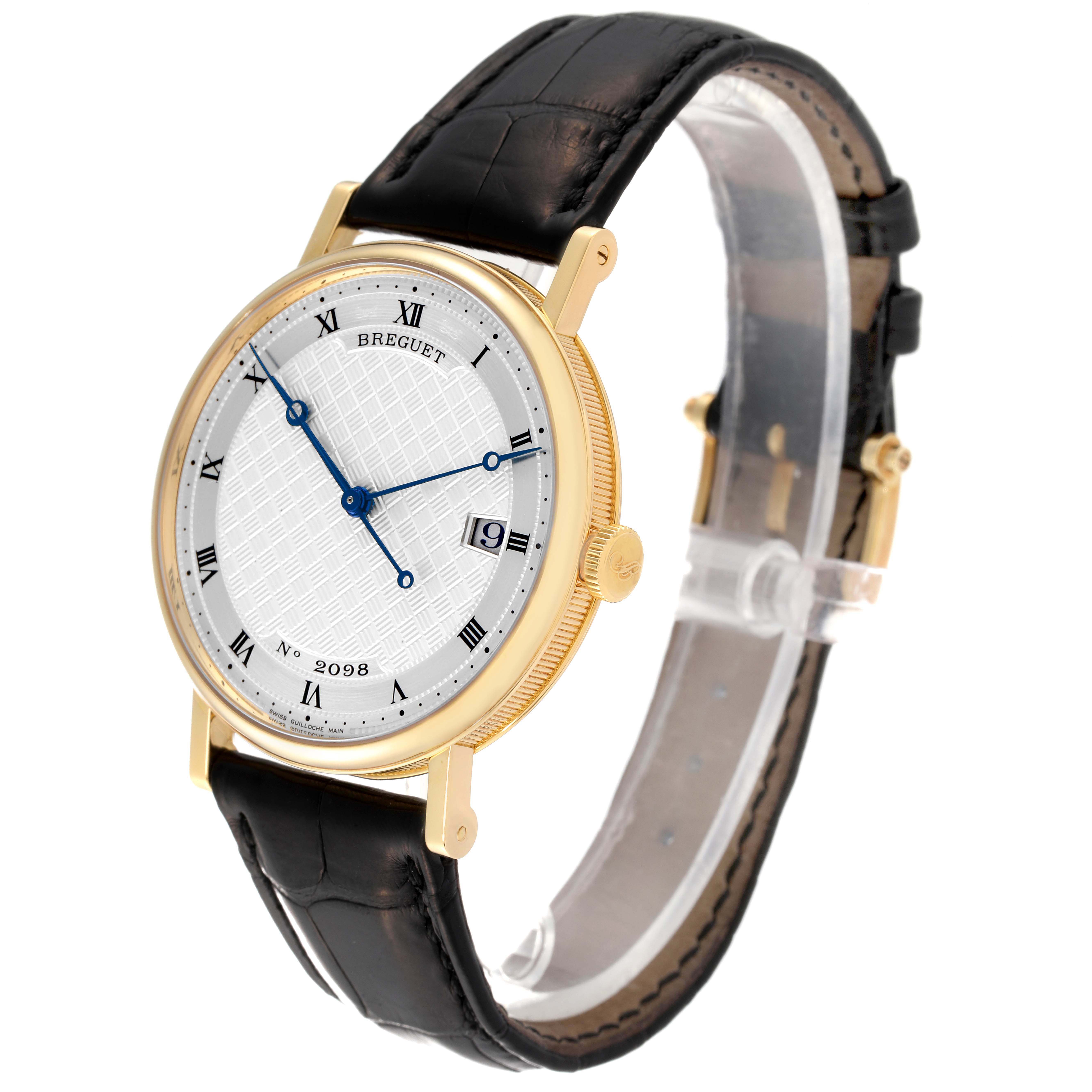 The Breguet Classique 5177BA/12/9V6 Men's Yellow Gold Silver Dial 5177BA/12/9V6 Men's Yellow Gold Silver Dial watch is shown at a slight angle displaying the face, Roman numeral indices, blue hands, and leather strap.