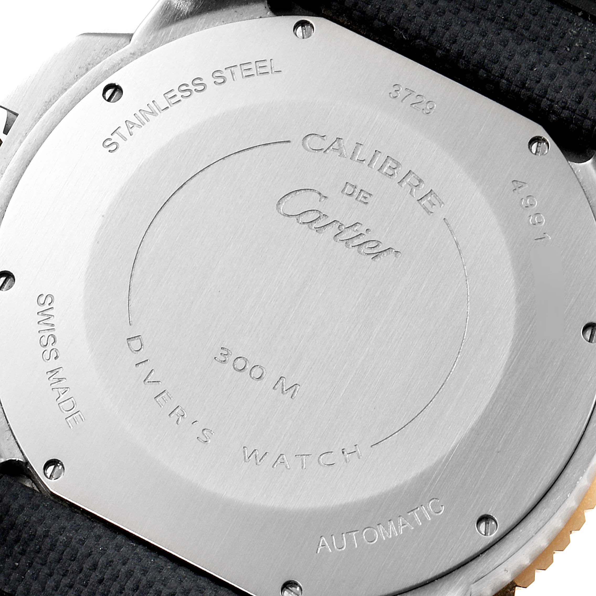 The image shows the back of a Calibre de Cartier watch by Cartier, highlighting its stainless steel casing and engravings.