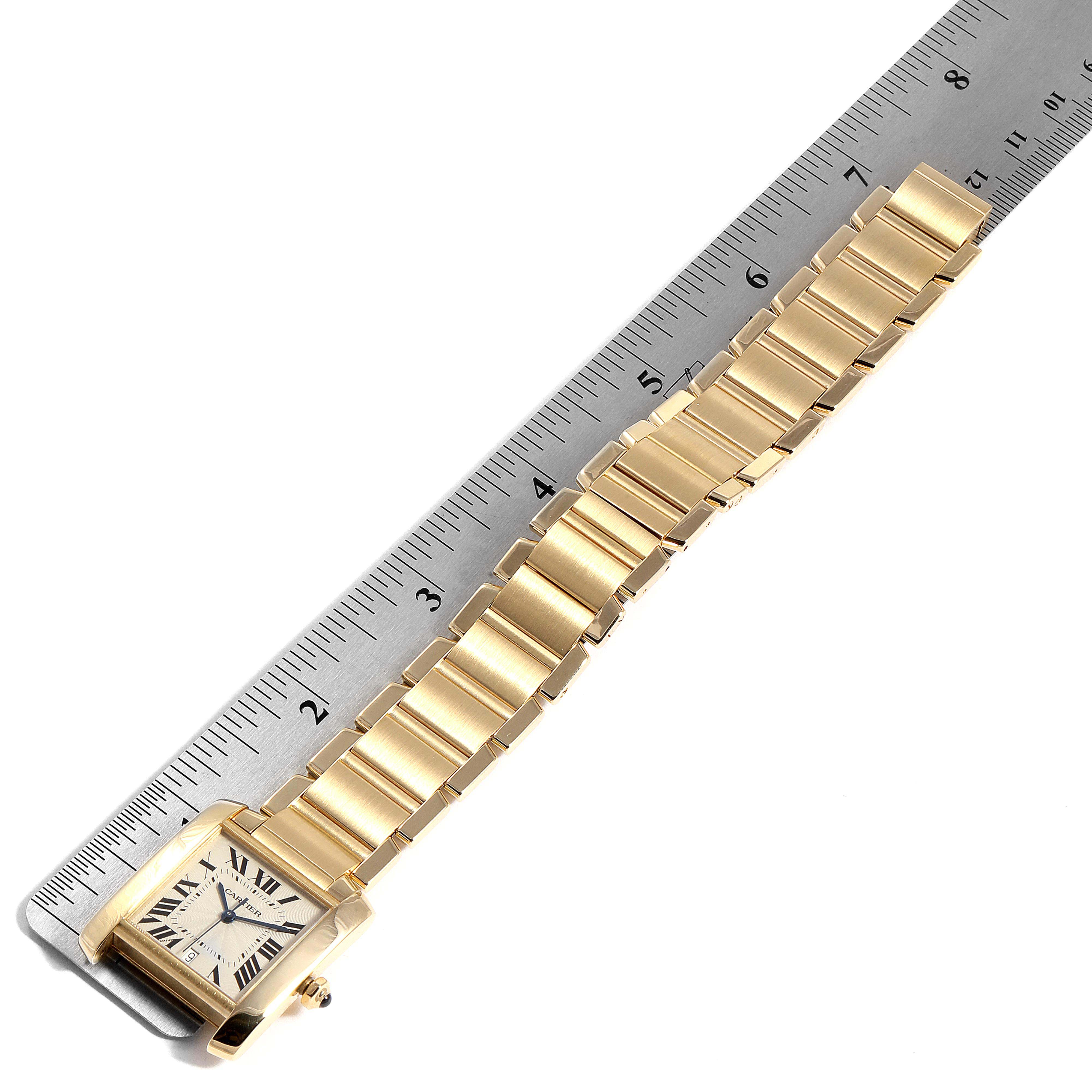 The image shows the Cartier Tank Française watch in a top-down angle, displaying the face and entire length of the gold bracelet alongside a ruler for scale.