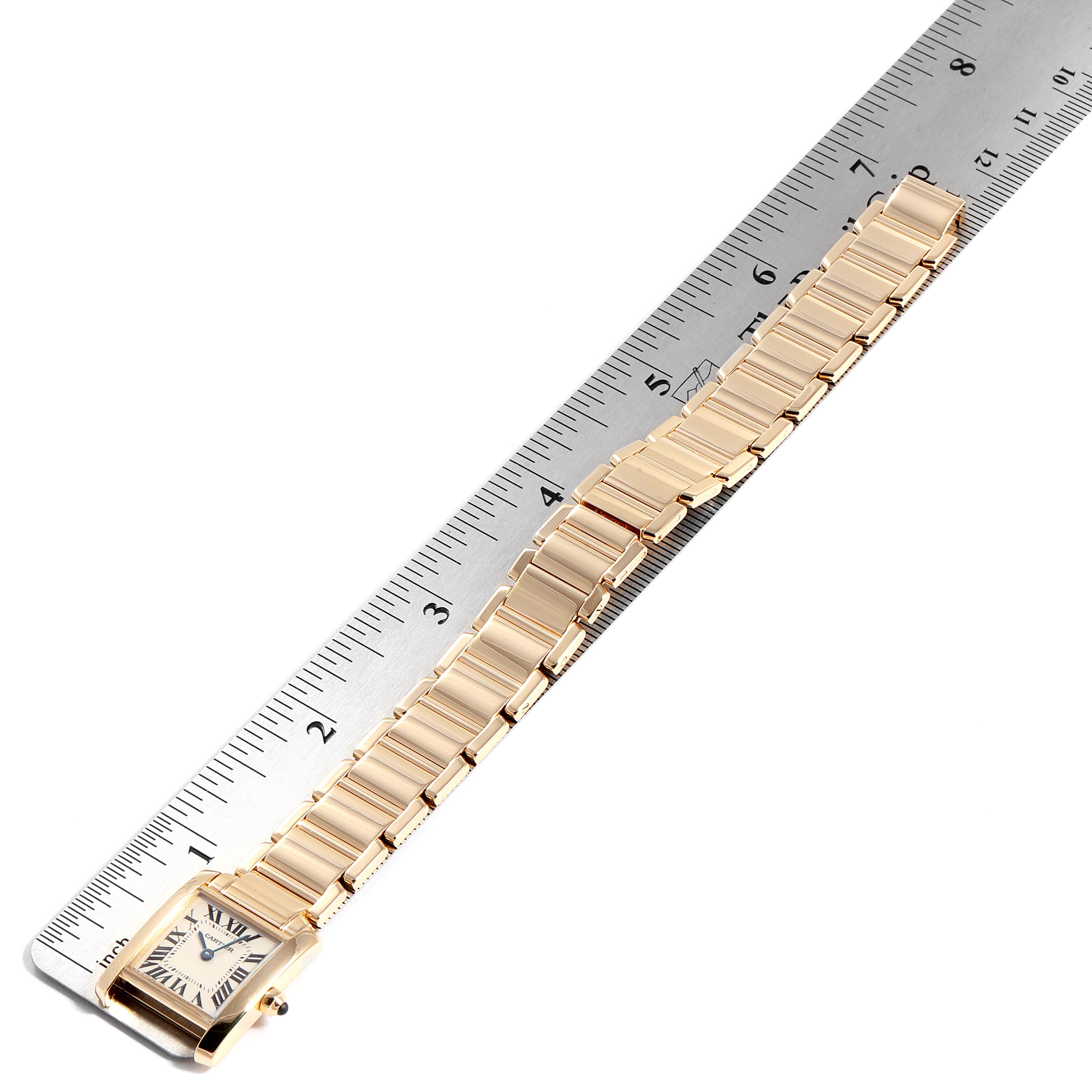 The Cartier Tank Française watch is shown from a top-down angle, displaying its face and entire bracelet alongside a ruler.