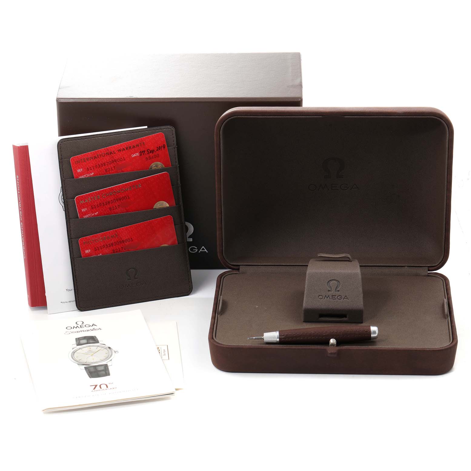 The image shows a boxed set for the Omega Museum 511.93.38.20.99.001 Men's Platinum Silver Dial 511.93.38.20.99.001 Men's Platinum Silver Dial model watch, including a case, manuals, warranty cards, and a tool.