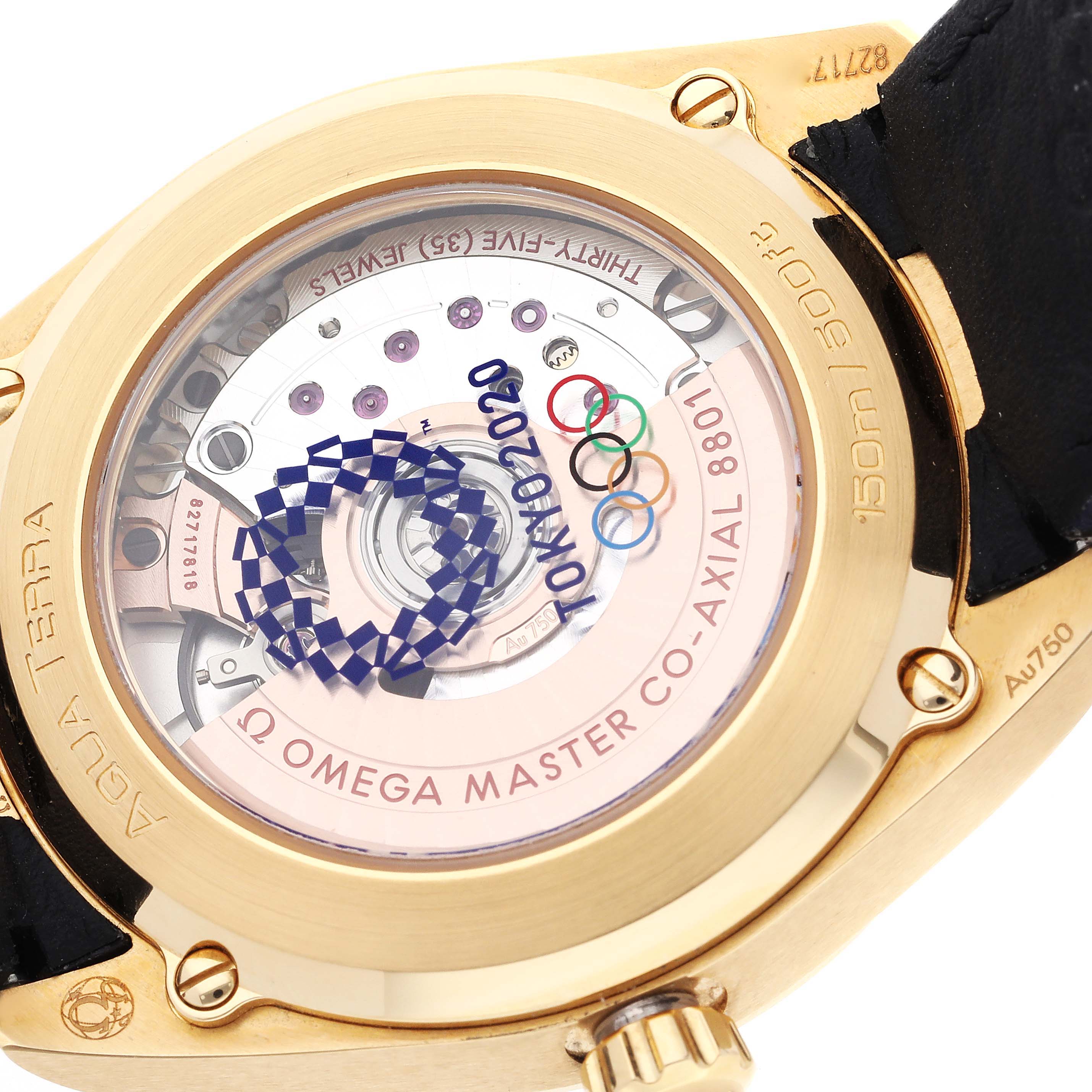 The image shows the Omega Aqua Terra 522.53.38.20.03.001 Men's Yellow Gold Blue Dial's case back, highlighting its movement and "Tokyo 2020" inscription with Olympic rings.