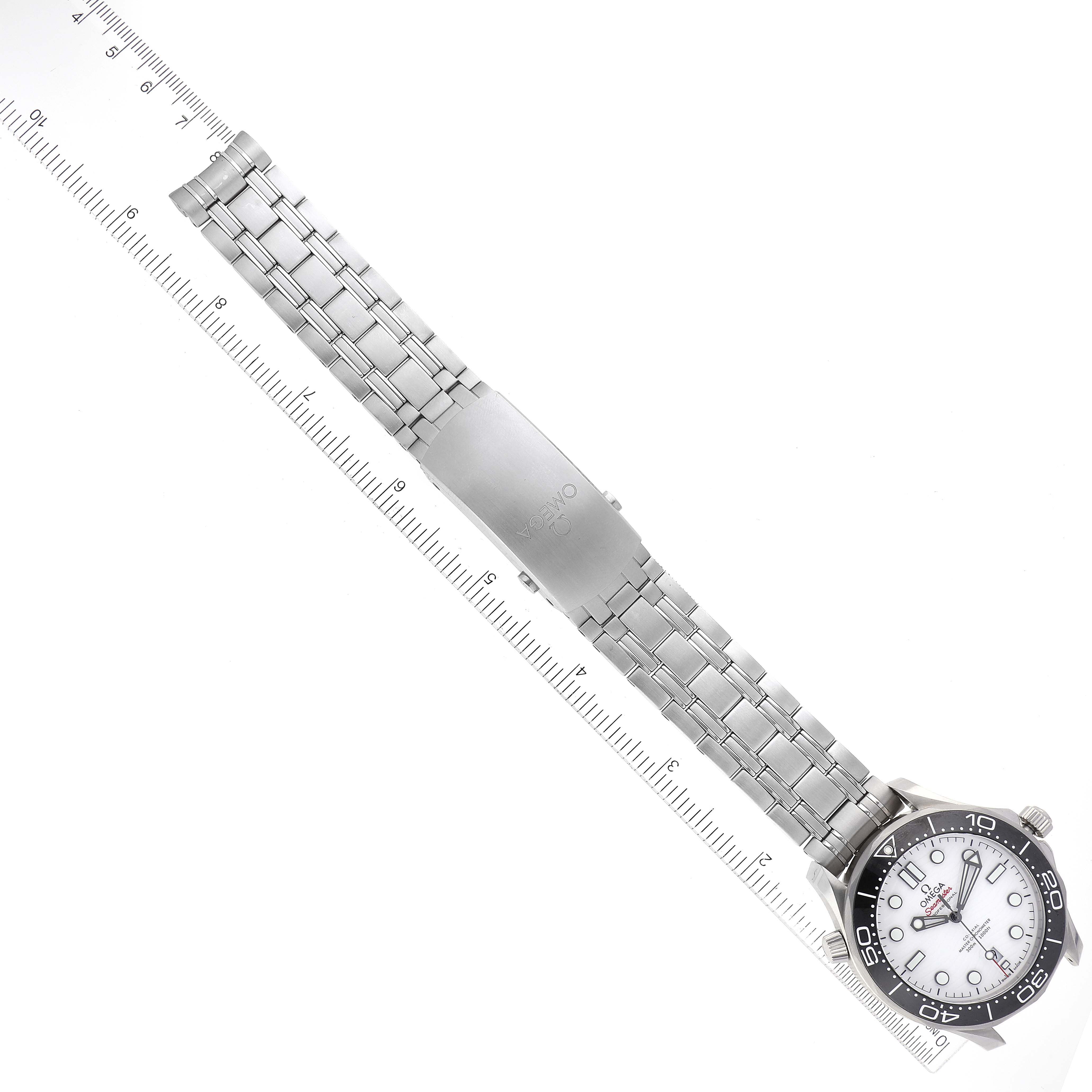 The image shows an overhead view of an Omega Seamaster 210.30.42.20.04.001 Men's Stainless Steel White Dial 210.30.42.20.04.001 Men's Stainless Steel White Dial watch, including its face, bezel, and metal bracelet alongside a ruler.