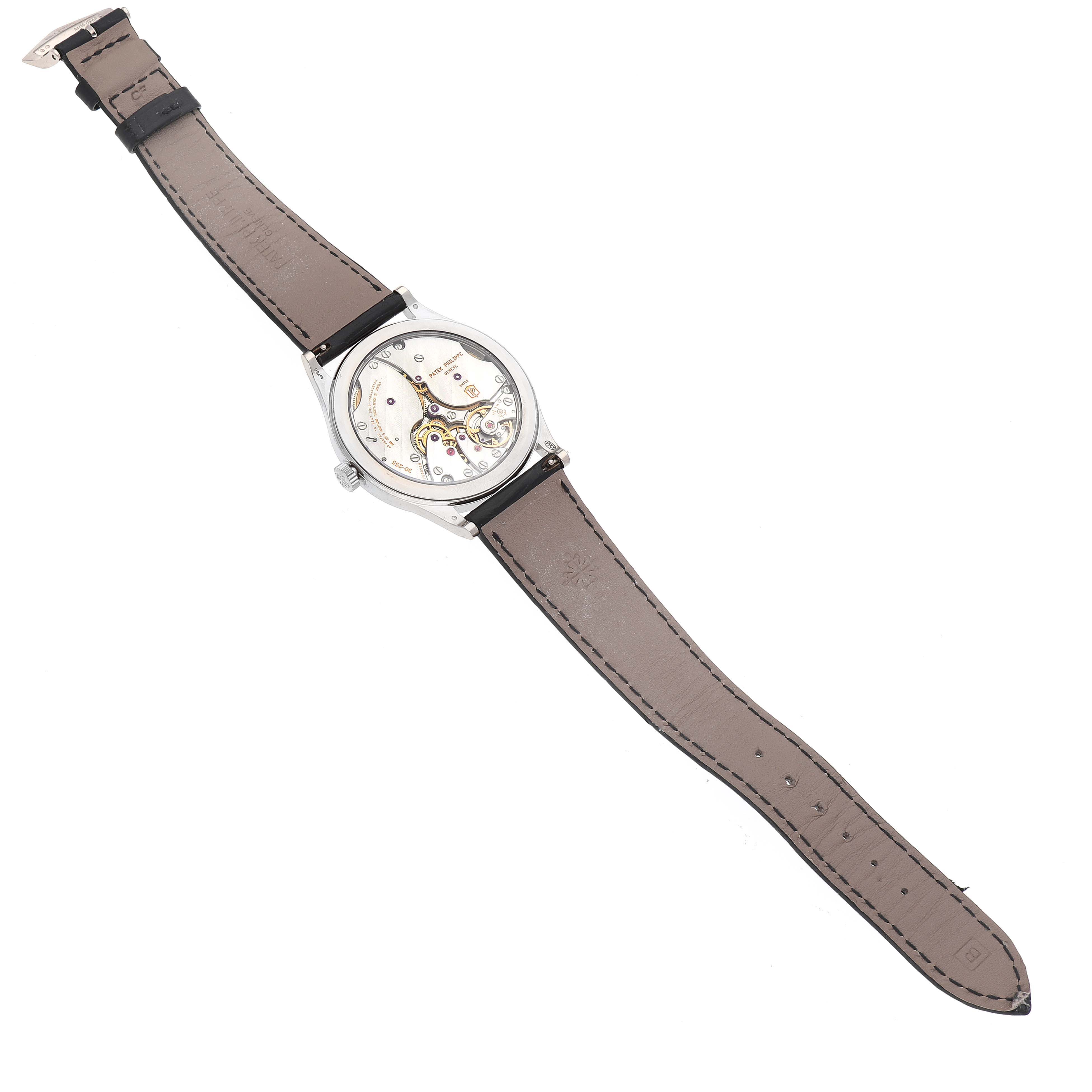 The image shows the underside of a Patek Philippe Calatrava 6119G-001 Men's White Gold Grey Dial 6119G-001 Men's White Gold Grey Dial watch, highlighting its movement and leather strap.