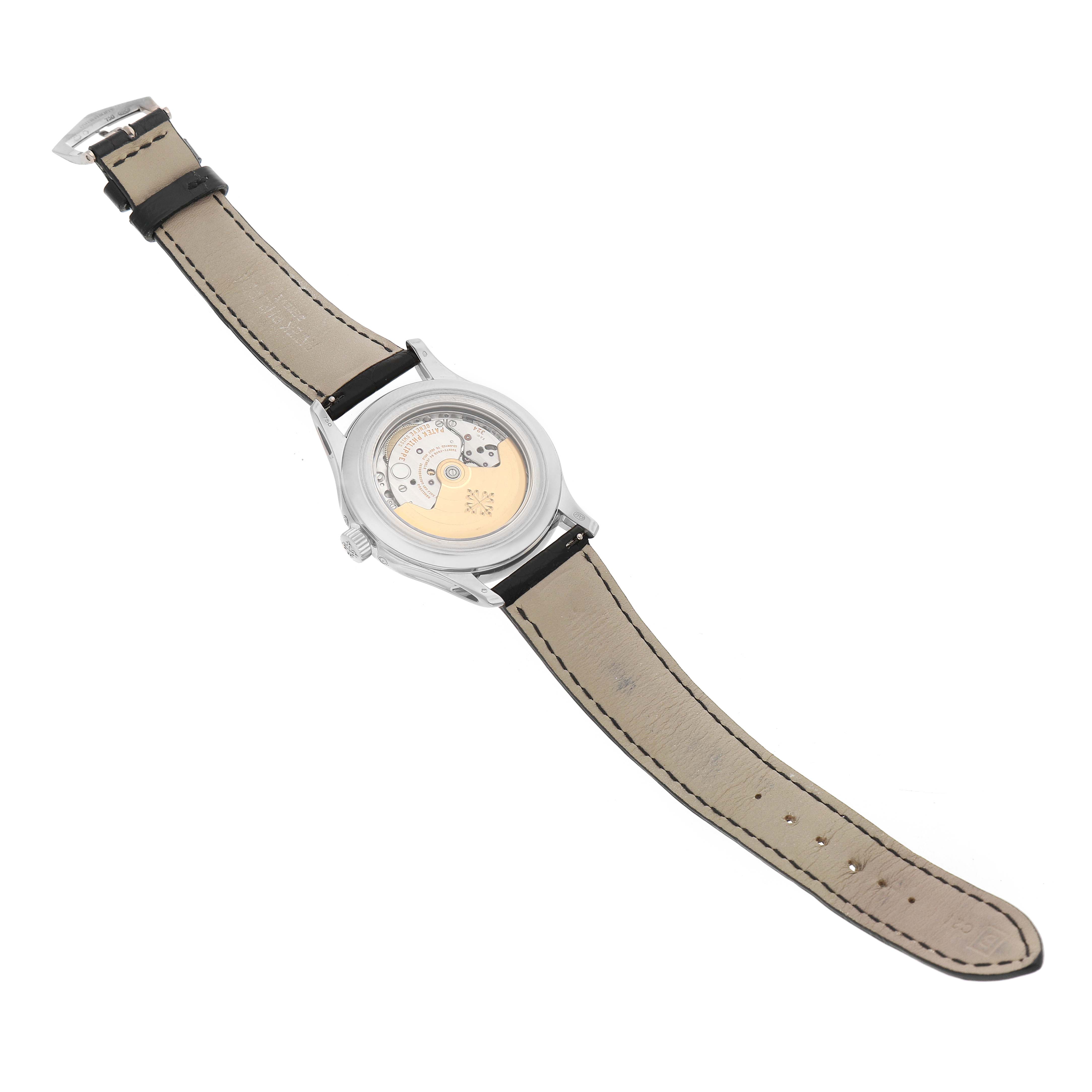 The image shows the back of a Patek Philippe Complications 5205G Men's White Gold Silver Dial watch, highlighting the movement through a transparent case back and leather strap.