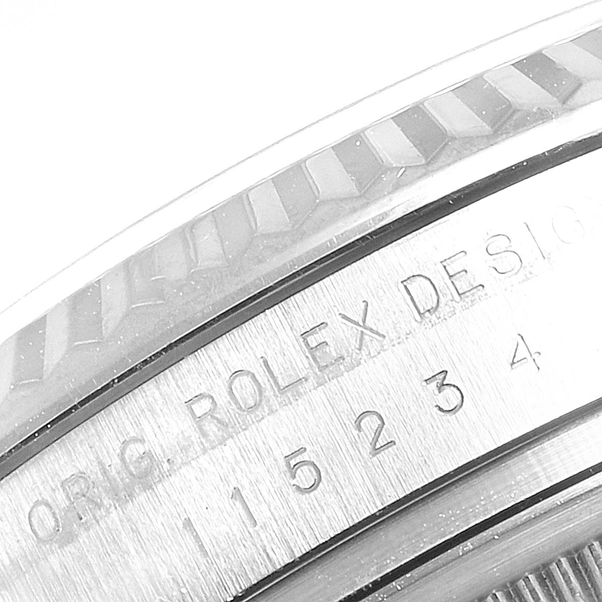 This image shows a close-up of the engraved bezel and case of a Rolex Date 115234 Men's Stainless Steel Black Dial 115234 Men's Stainless Steel Black Dial model watch.