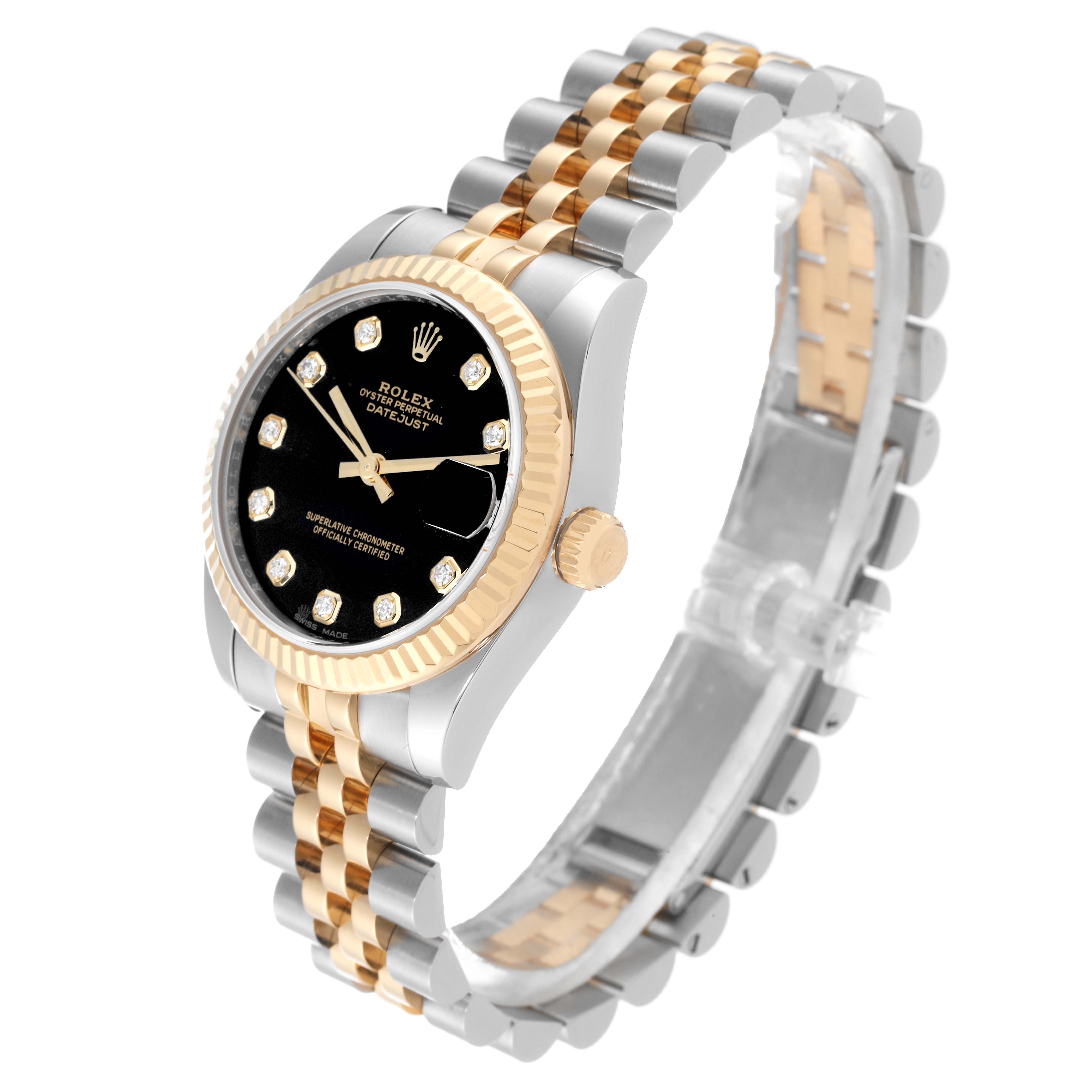 The Mid-Size Rolex watch is shown at an oblique angle, highlighting its black dial, fluted bezel, and two-tone bracelet.