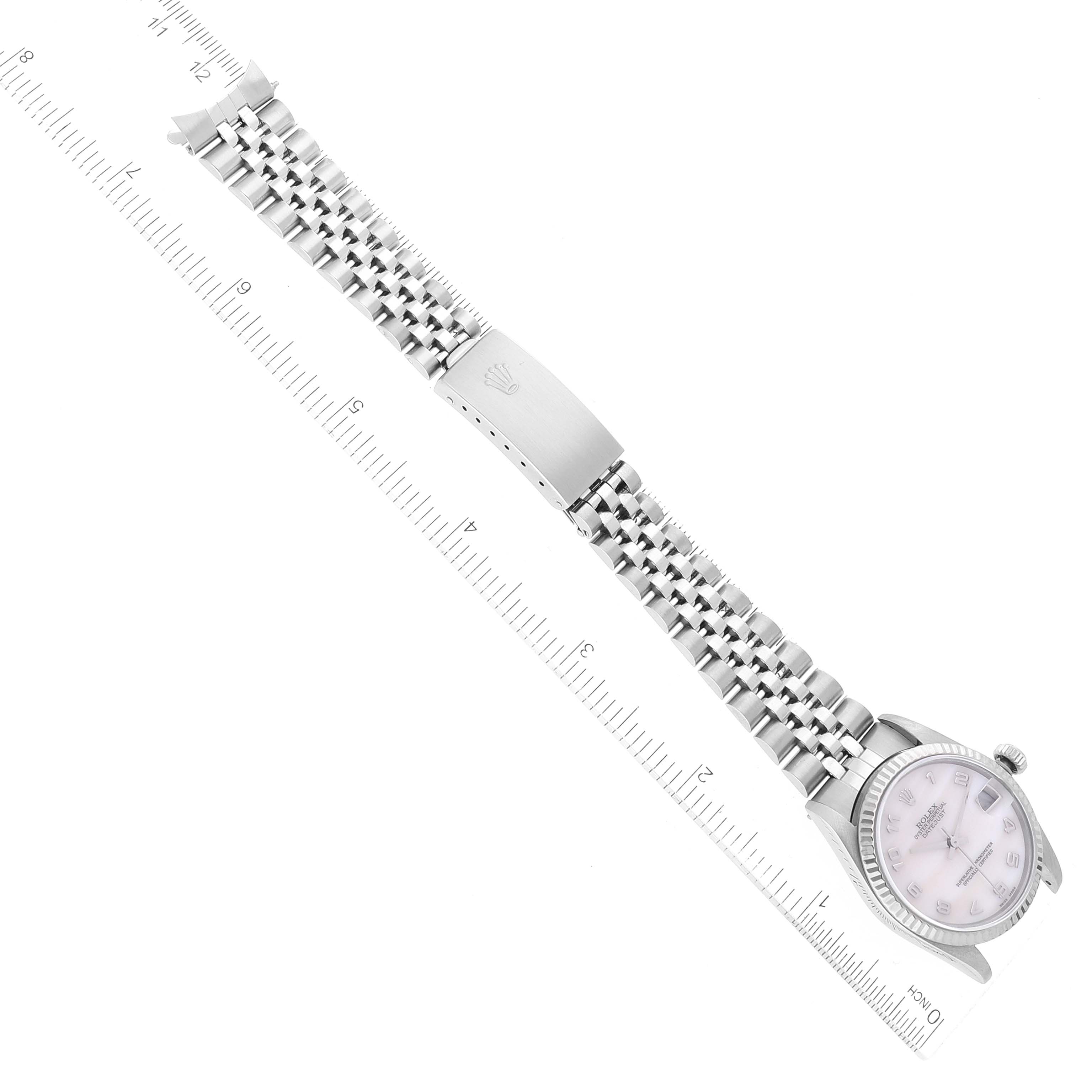 This image shows a top view of a Rolex Mid-Size 78274 Women
s Stainless Steel Mother of Pearl Dial 78274 Women
s Stainless Steel Mother of Pearl Dial model watch, including the face, bracelet, and clasp next to a ruler.