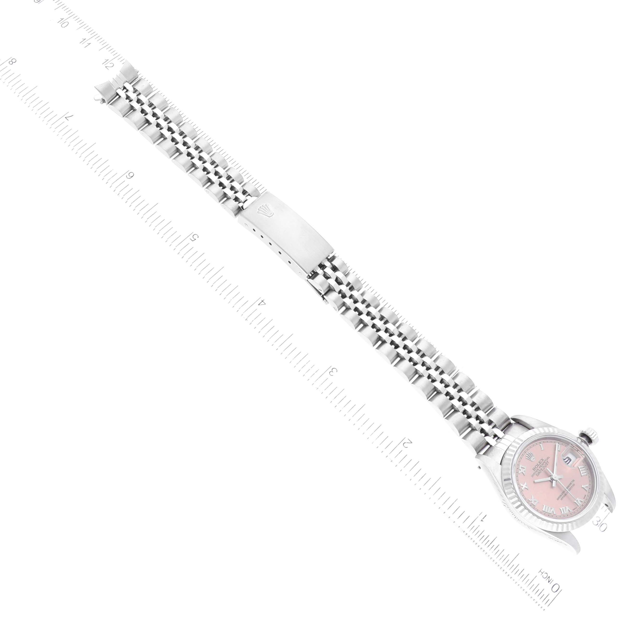 The image shows a Rolex Datejust 69174 Women's Stainless Steel Pink Dial 69174 Women's Stainless Steel Pink Dial watch at an angle, including its face, bezel, bracelet, and clasp, alongside a ruler for scale.