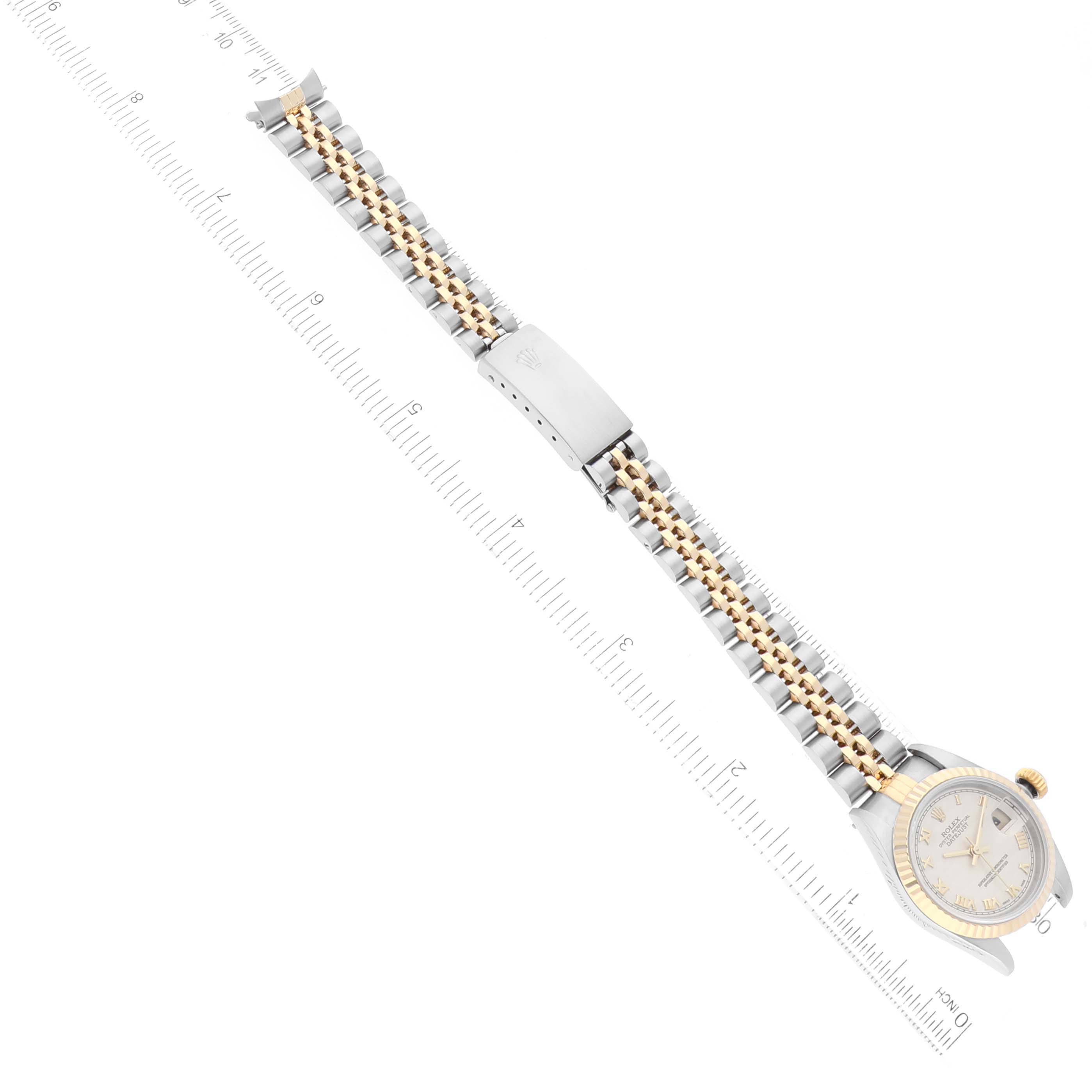 The image shows a top-down view of a Rolex Datejust 79173 Women's Steel and Gold (two tone) White Dial 79173 Women's Steel and Gold (two tone) White Dial watch, displaying its face and entire two-tone strap aligned along a ruler.