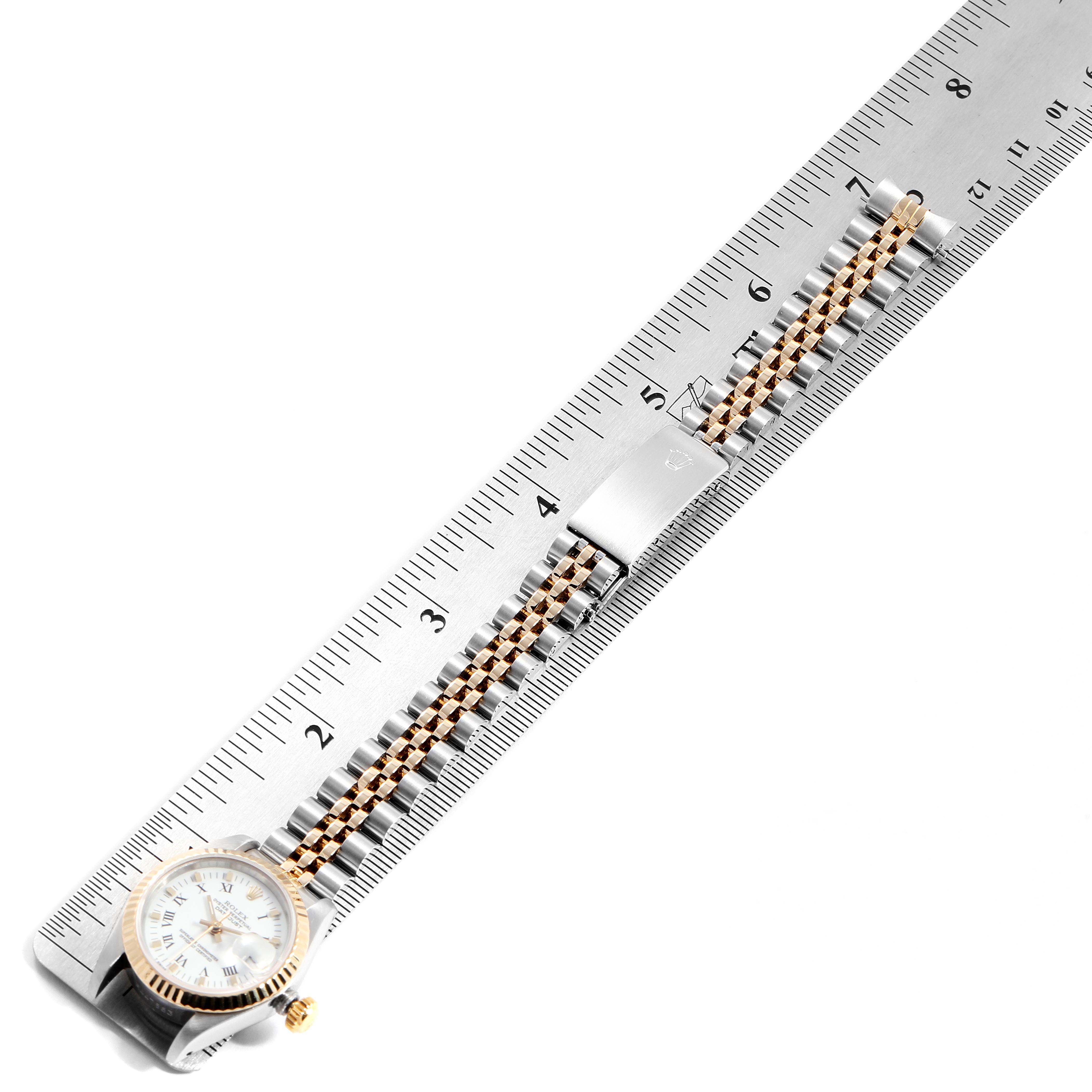This image shows a top-down view of a Rolex Datejust 69173 Women
s Steel and Gold (two tone) White Dial 69173 Women
s Steel and Gold (two tone) White Dial watch, focusing on the band and clasp placed on a ruler.