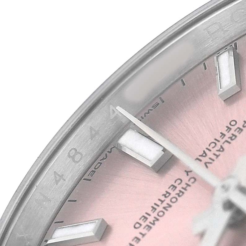 The image shows a close-up of the dial and part of the bezel of a Rolex Oyster Perpetual 124200 Men's Stainless Steel Pink Dial, highlighting the hour markers and hands.