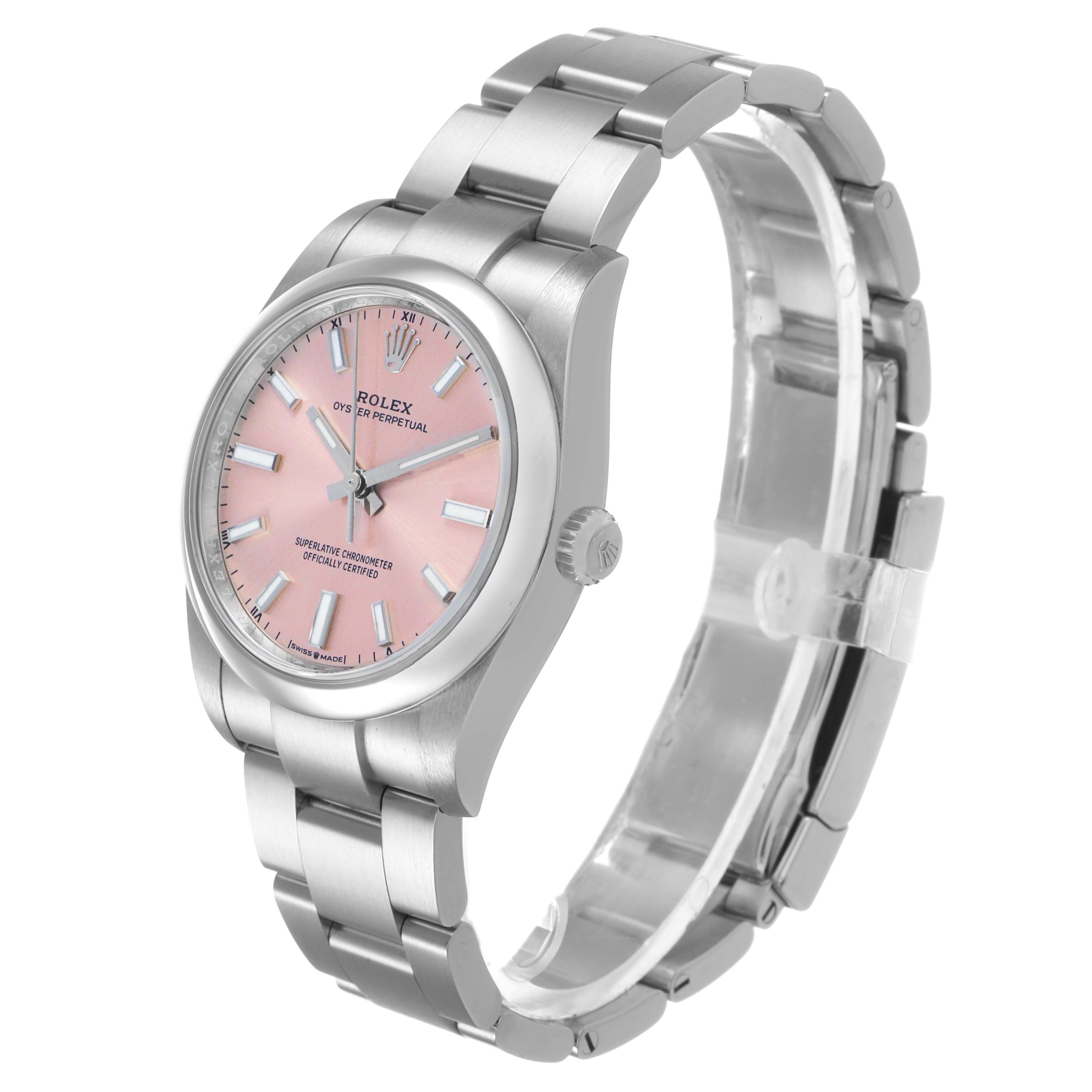 The image shows a Rolex Oyster Perpetual 124200 Men's Stainless Steel Pink Dial watch from a three-quarter angle, highlighting the pink dial and metal bracelet.
