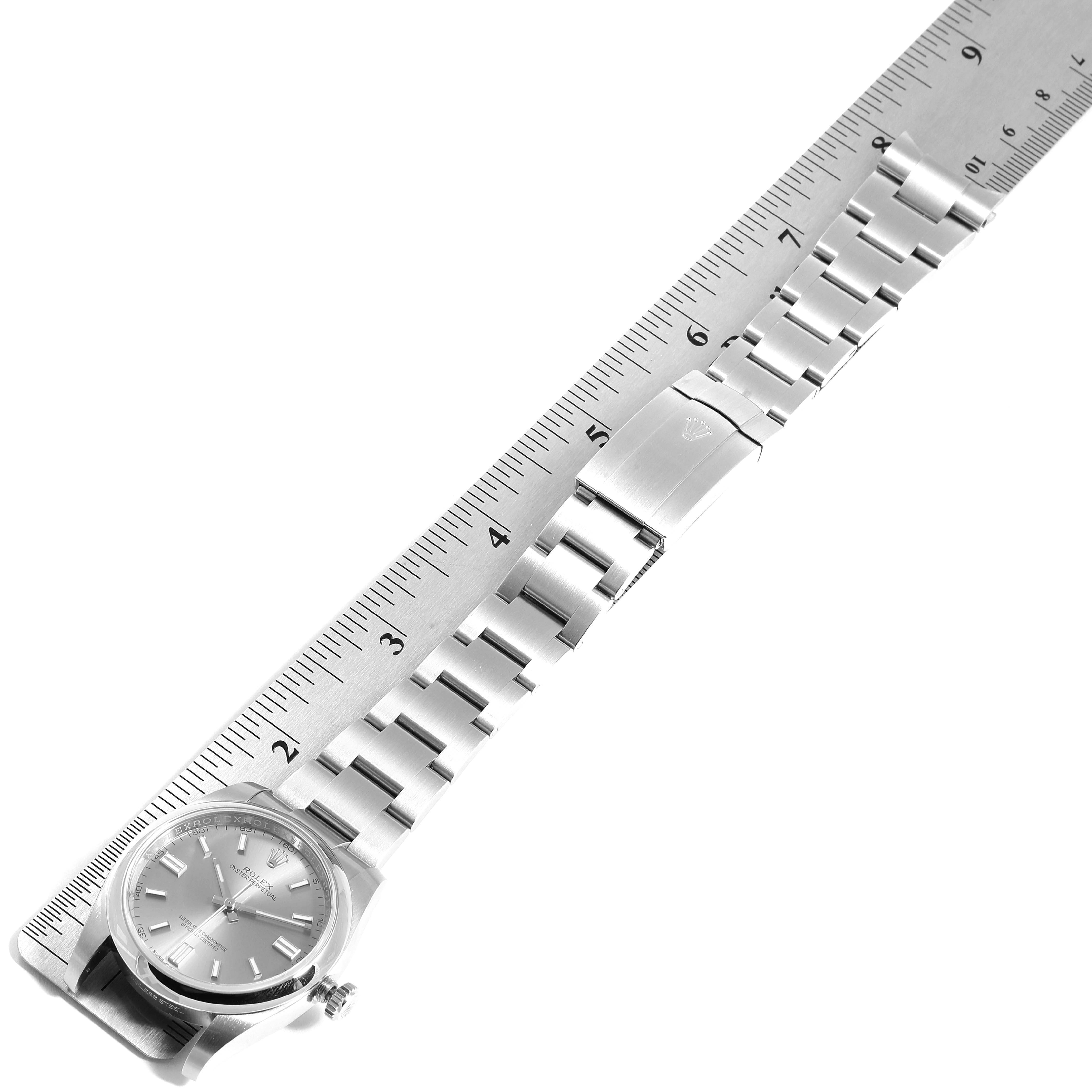 The image shows a Rolex Datejust 116000 Men
s Stainless Steel Grey Dial 116000 Men
s Stainless Steel Grey Dial watch laid flat, displaying the face and metal bracelet next to a ruler for measurement.