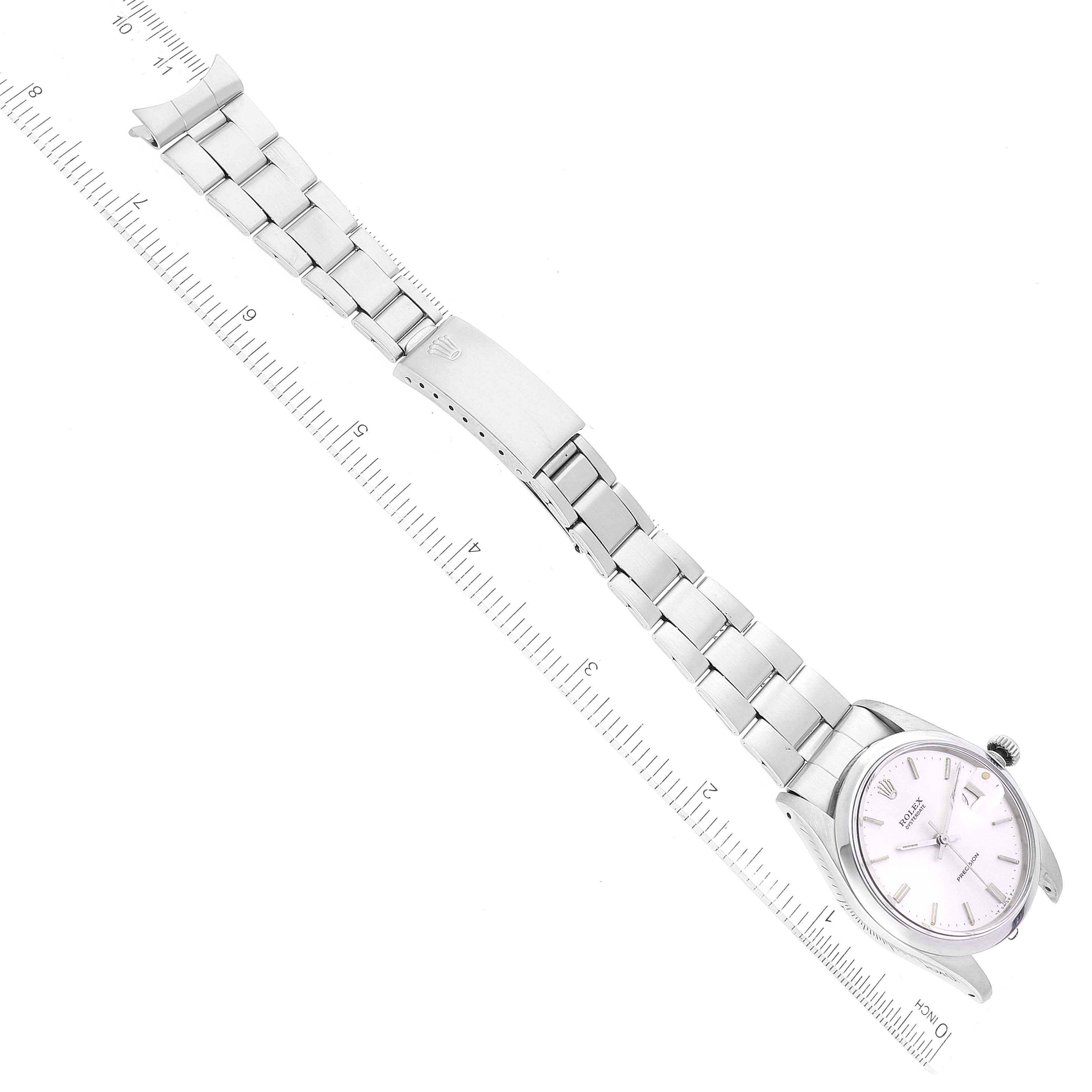 The Vintage Collection Rolex watch is shown from an aerial view, displaying the face, bezel, bracelet, and clasp, alongside a measuring scale.