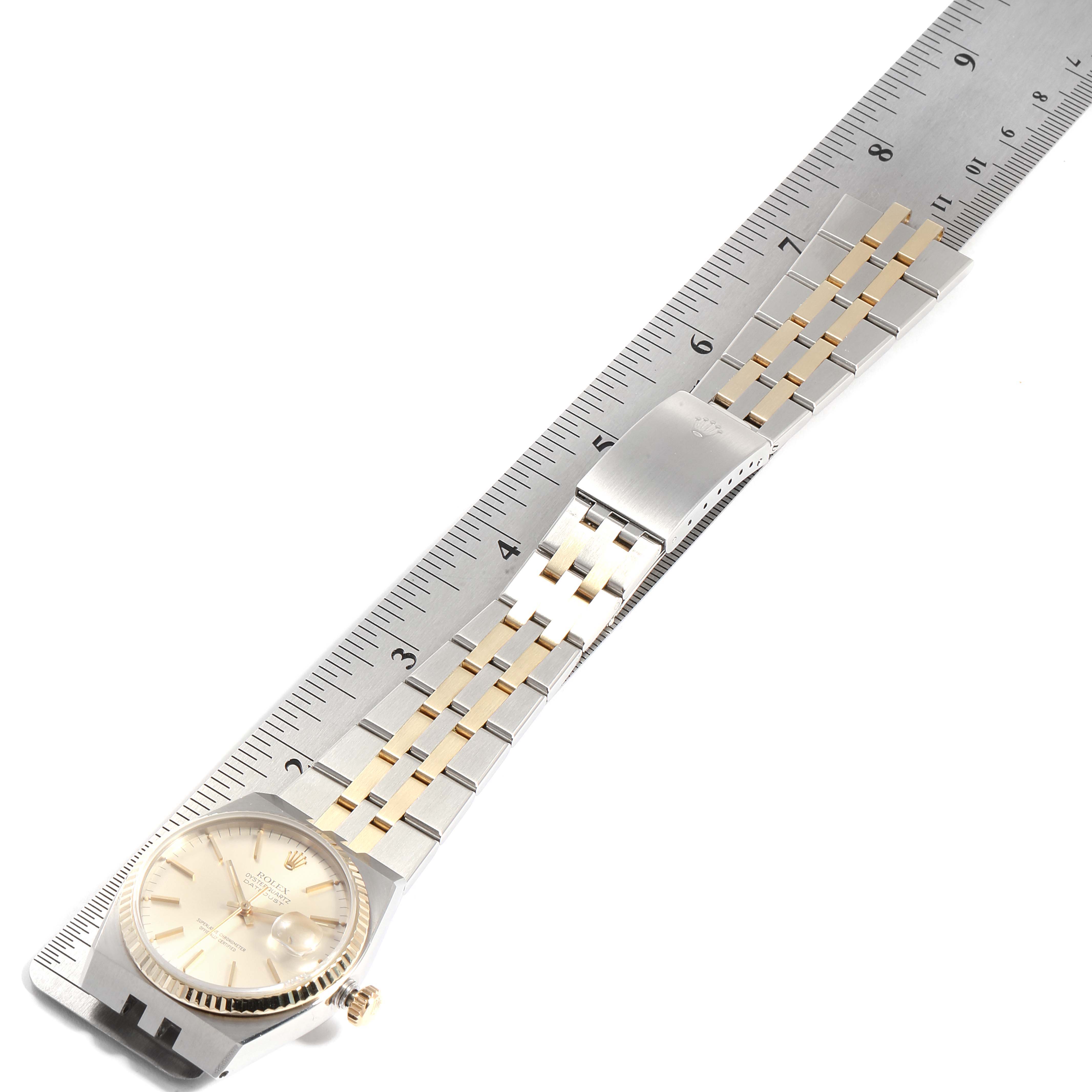 The image shows a Rolex Oysterquartz 17013 Men
s Steel and Gold (two tone) Silver Dial 17013 Men
s Steel and Gold (two tone) Silver Dial watch laid flat next to a ruler, displaying its face, bracelet, and clasp.