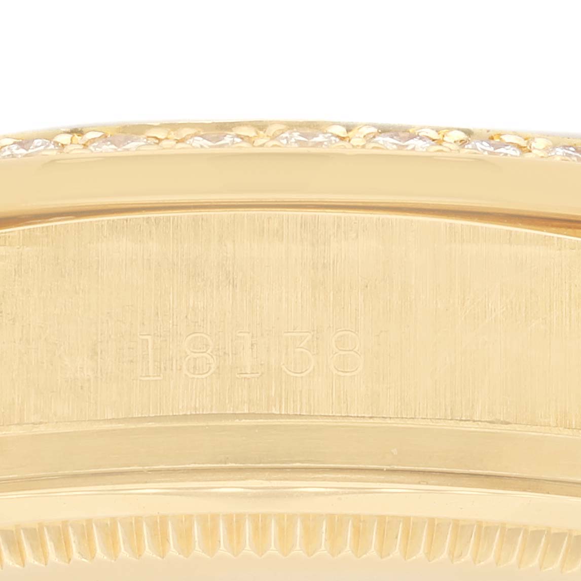 This image shows a close-up of the side of a Rolex President 18138 Men
s Yellow Gold Champagne Dial 18138 Men
s Yellow Gold Champagne Dial model watch, including its serial number and bezel.