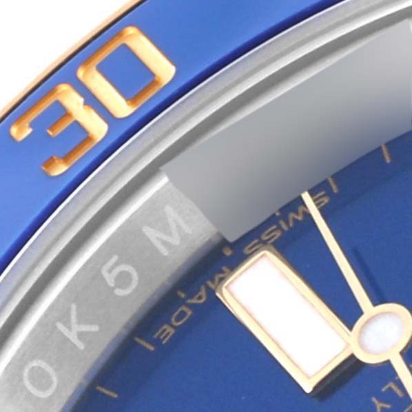 This close-up image shows the blue bezel, part of the dial, and marker details of the Rolex Submariner 116613LB Men's Steel and Gold (two tone) Blue Dial 116613LB Men's Steel and Gold (two tone) Blue Dial.