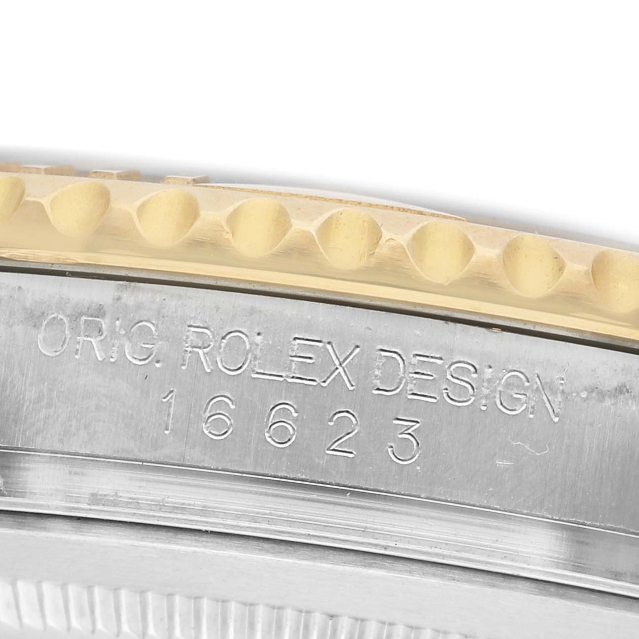 The image shows the side of a Rolex Yacht-Master 16623 Men's Steel and Gold (two tone) White Dial, highlighting the engraved model number and part of the bezel.