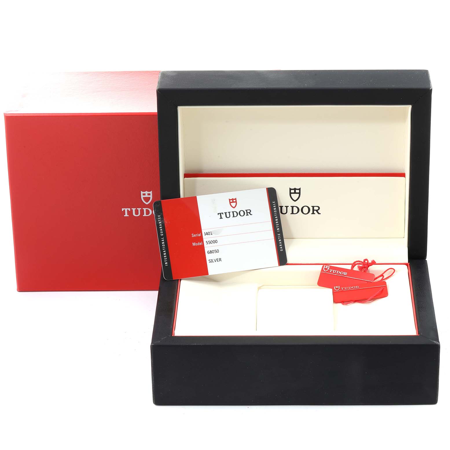 The image shows the packaging and accessories for a Tudor Glamour M55000-0001 Men's Stainless Steel Silver Dial M55000-0001 Men's Stainless Steel Silver Dial model watch, including the box, warranty card, and tags.