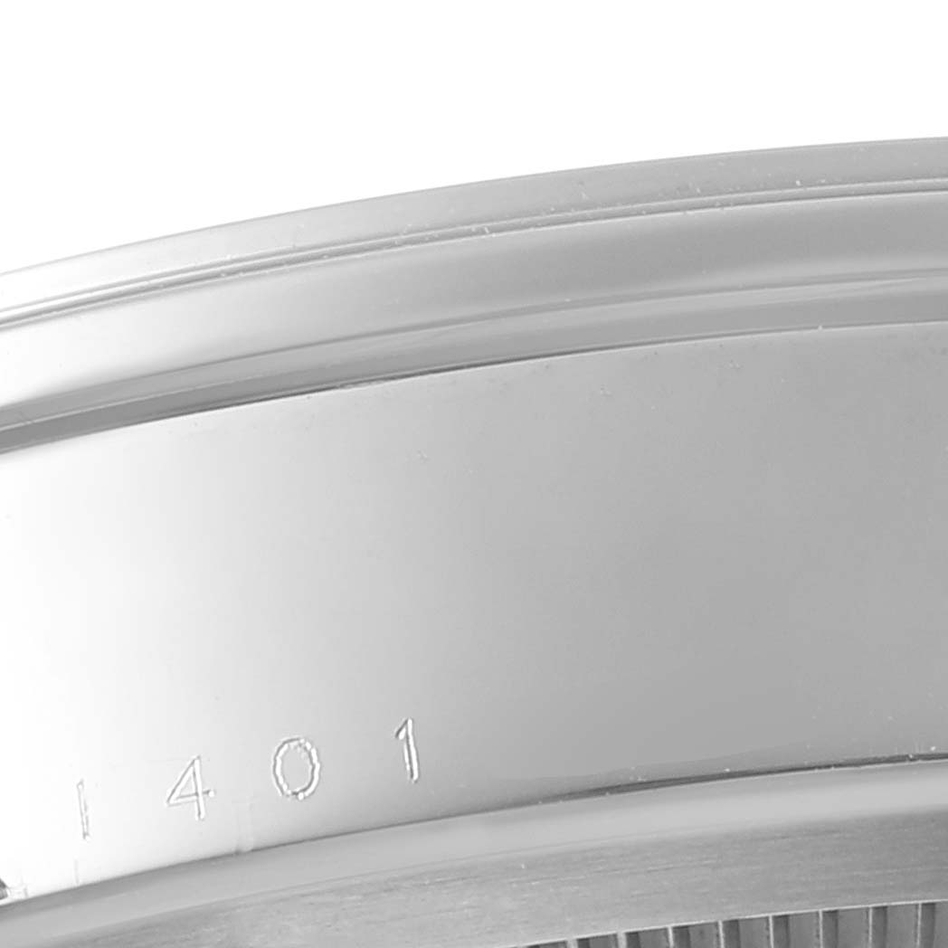 This close-up image shows part of the case back of a Tudor Glamour M55000-0001 Men's Stainless Steel Silver Dial M55000-0001 Men's Stainless Steel Silver Dial model watch, focusing on its edge and engraved numbers.