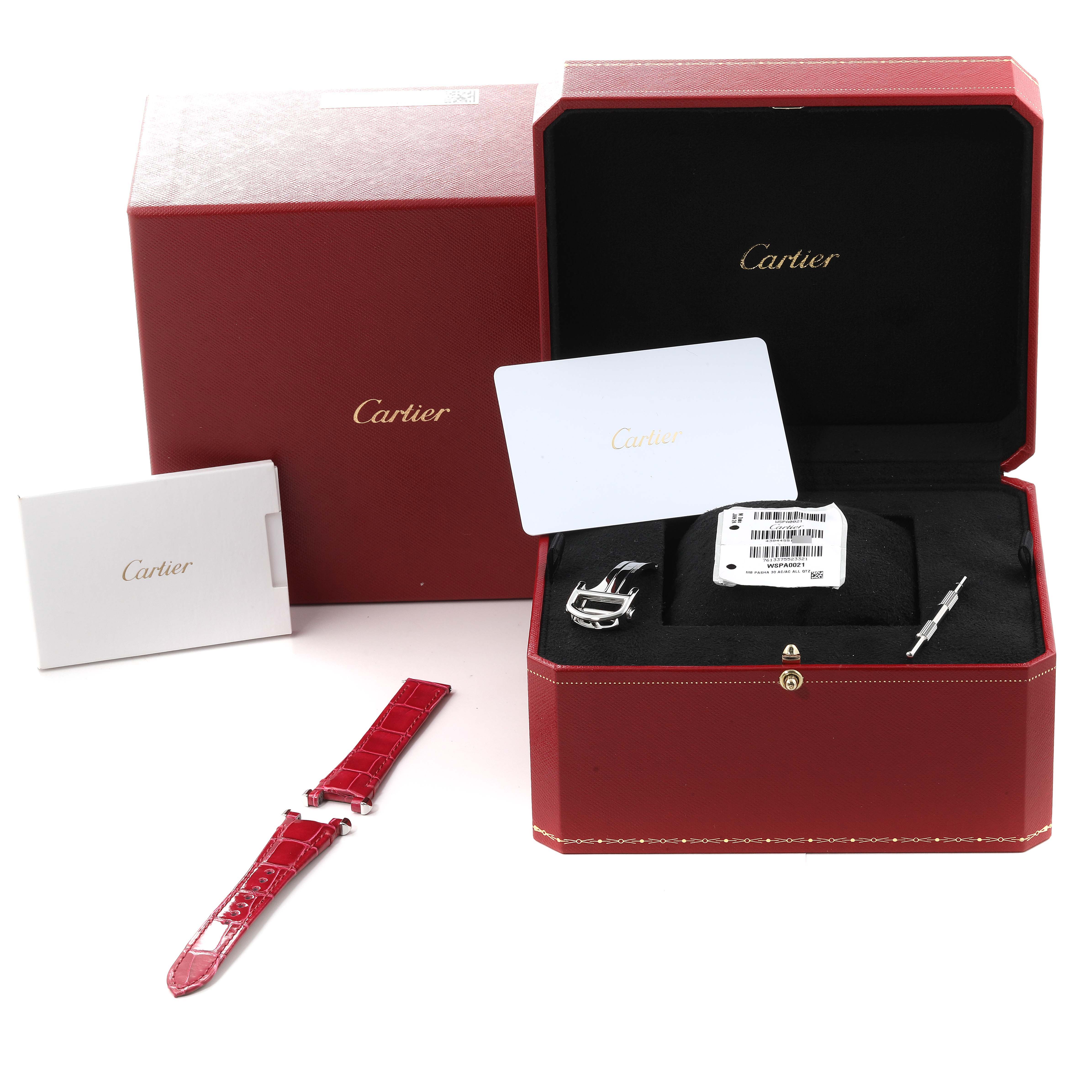 The image shows a Cartier Pasha WSPA0021 Women's Stainless Steel Silver Dial WSPA0021 Women's Stainless Steel Silver Dial model watch box with accessories, including extra straps and a tool.