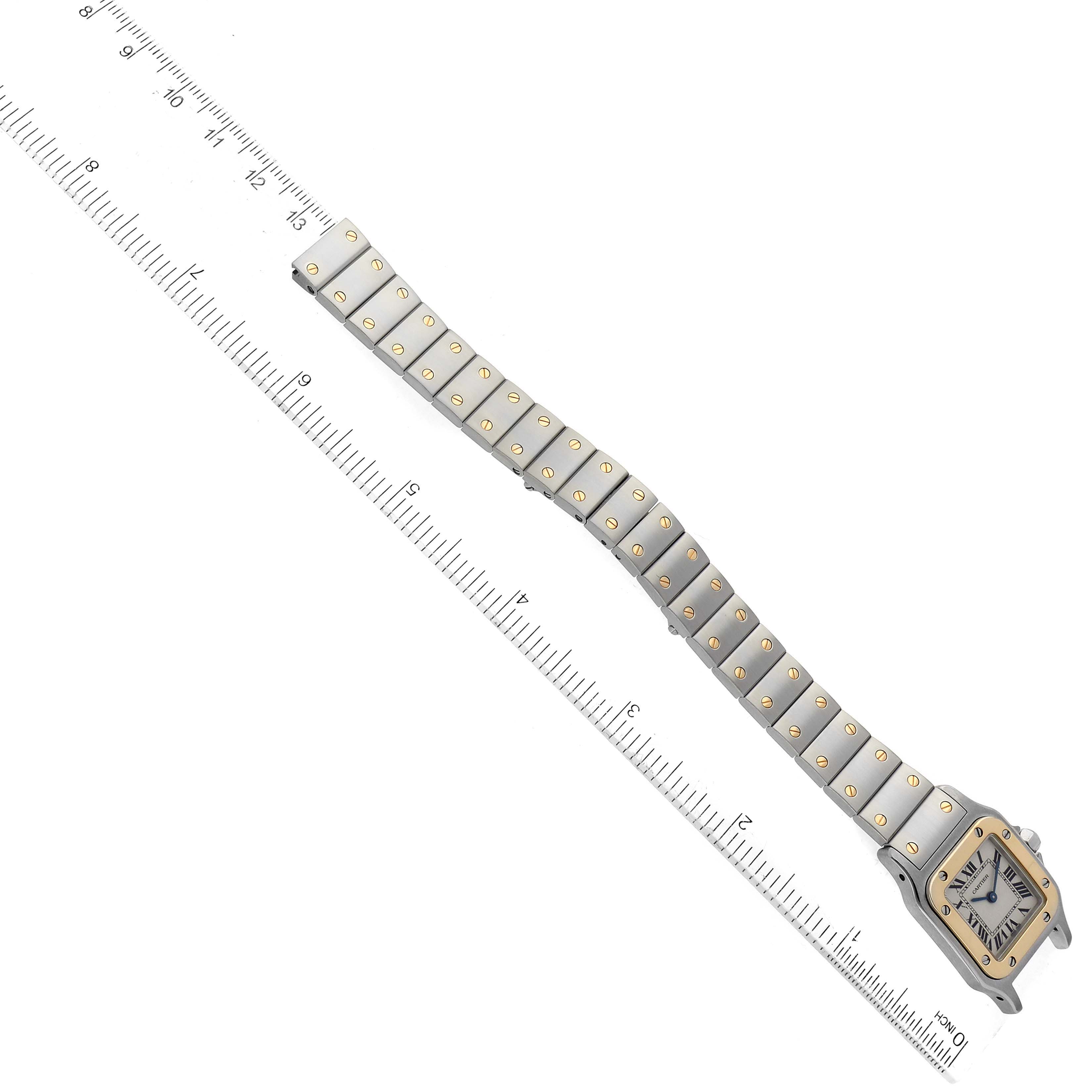 The image shows an overhead view of a Cartier Santos W20012C4 Women's Stainless Steel Silver Dial W20012C4 Women's Stainless Steel Silver Dial watch with a ruler for scale, highlighting the watch face and bracelet.
