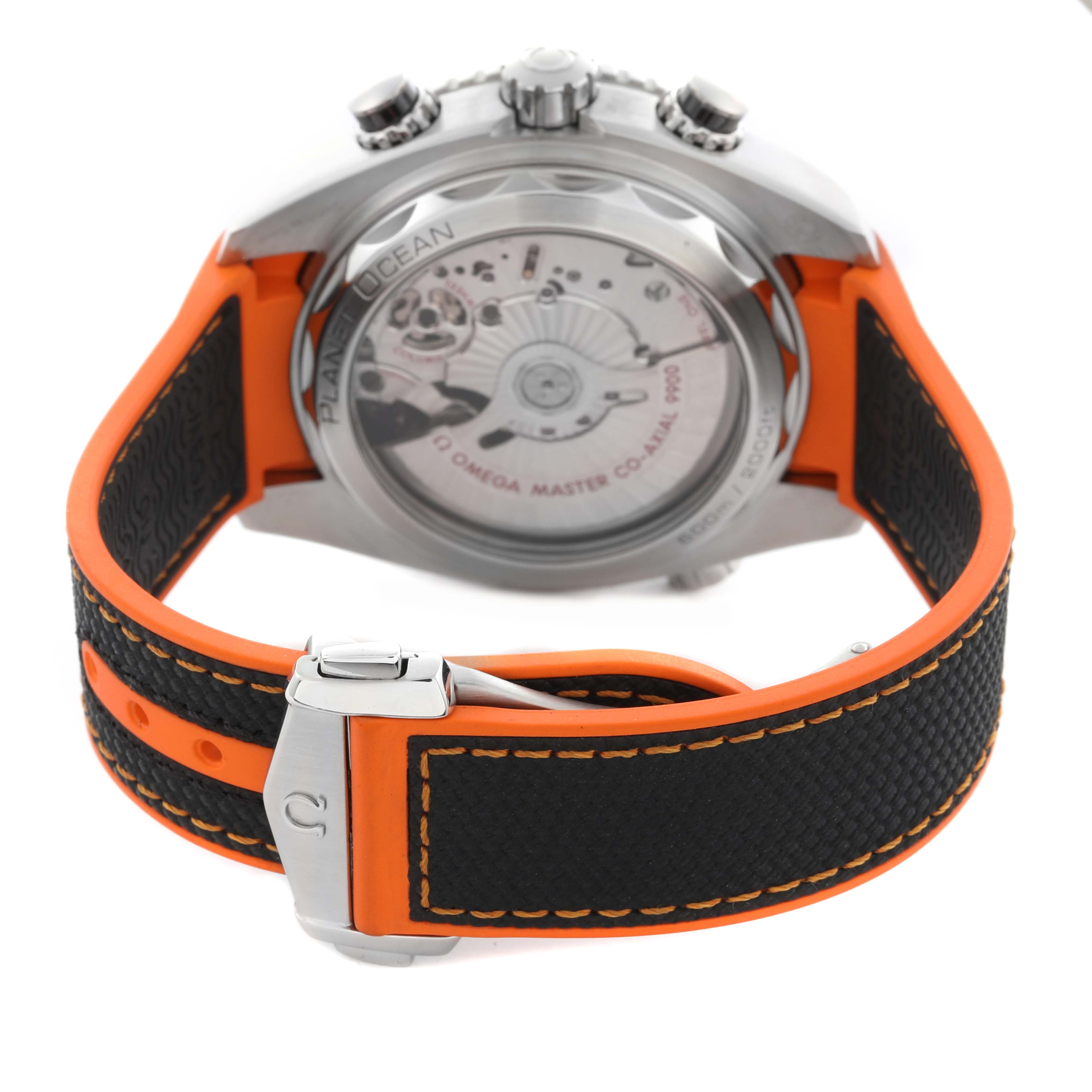 The Omega Planet Ocean 215.32.46.51.01.001 Men
s Stainless Steel Black Dial 215.32.46.51.01.001 Men
s Stainless Steel Black Dial watch is shown from the back, displaying the transparent case back and the clasp of the orange and black strap.