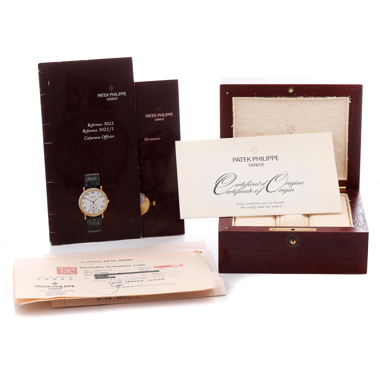 The image shows a Patek Philippe Calatrava 5022J-001 Men
s Yellow Gold Champagne Dial 5022J-001 Men
s Yellow Gold Champagne Dial box, documents, and manual from a top angle.