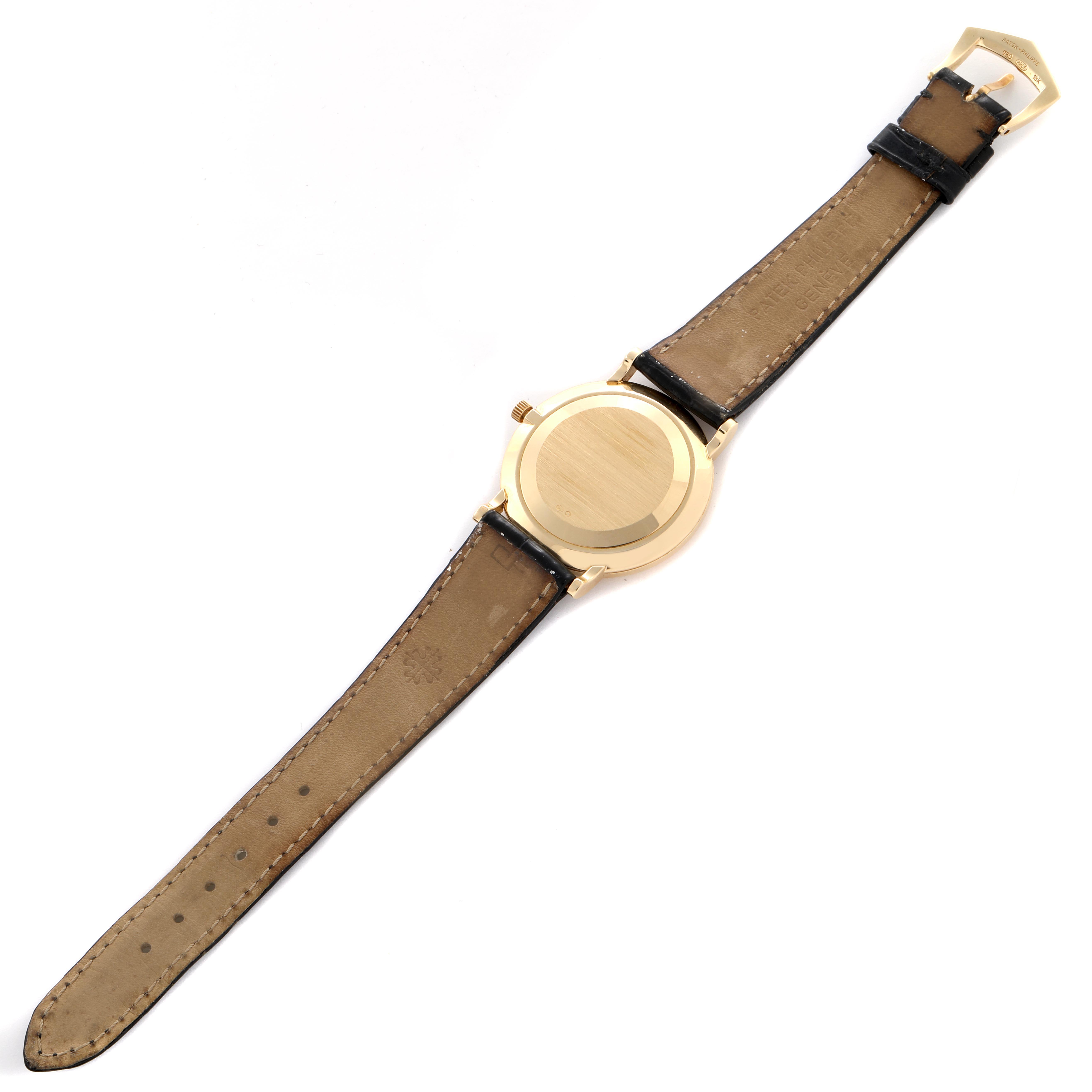 The image shows the back of a Patek Philippe Calatrava 5022J-001 Men
s Yellow Gold Champagne Dial 5022J-001 Men
s Yellow Gold Champagne Dial watch, displaying its case and leather strap.