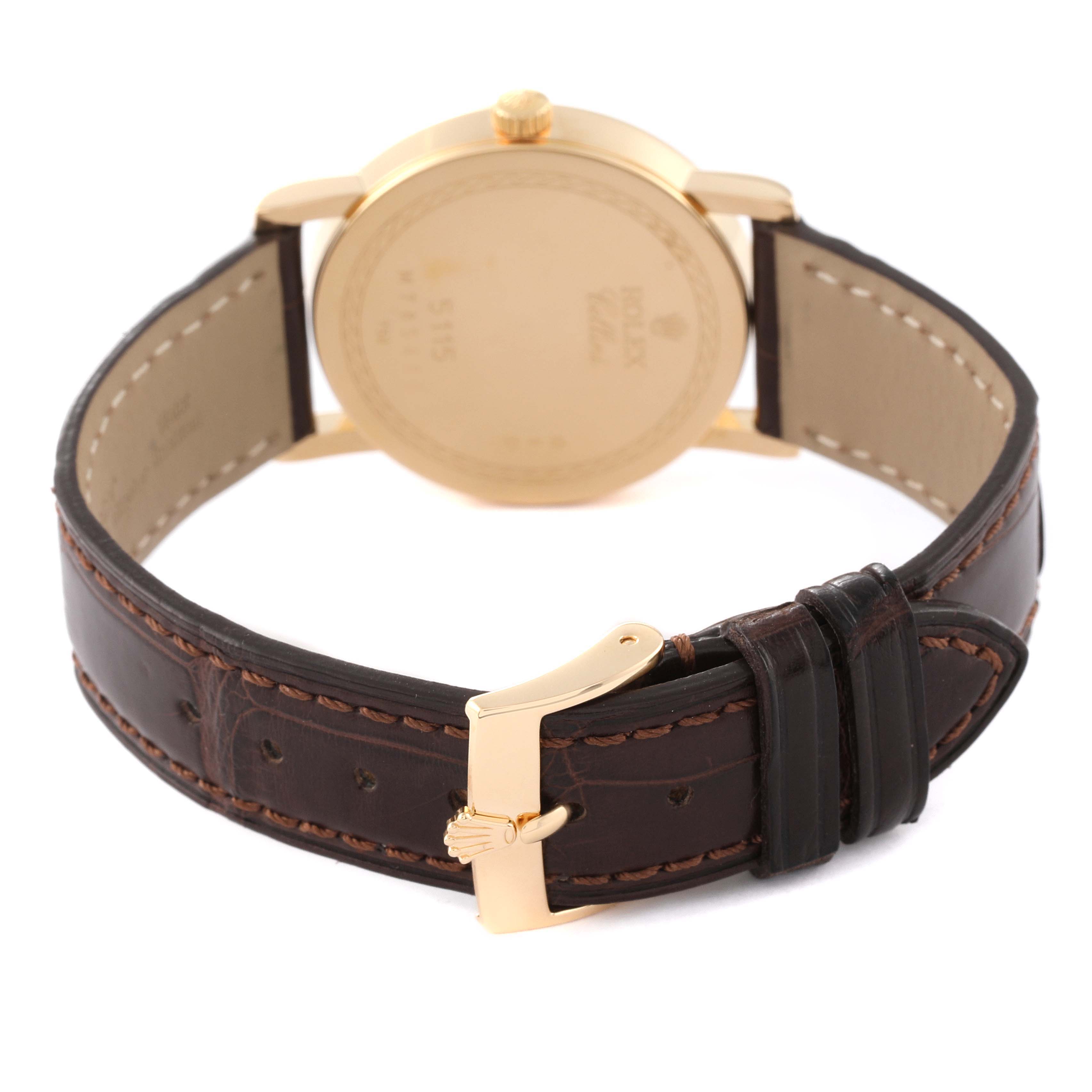 This image shows the back view of a Rolex Cellini 5115 Men's Yellow Gold Beige Dial 5115 Men's Yellow Gold Beige Dial watch, highlighting the gold case back and leather strap with a gold buckle.