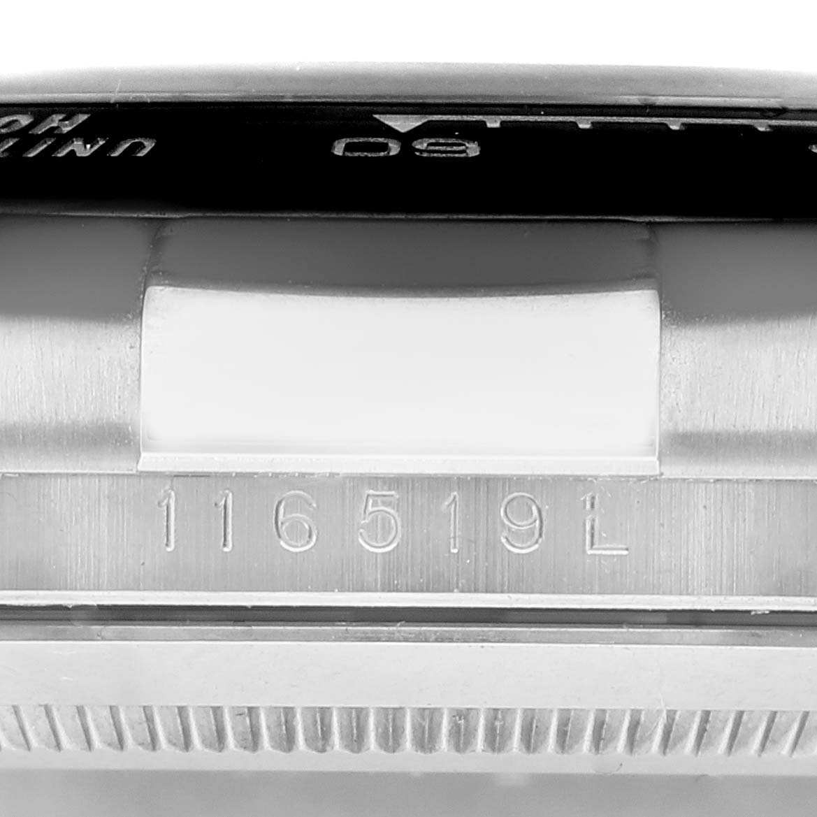 The image shows a close-up of the side of a Rolex Daytona 116519 Men's White Gold Grey Dial 116519 Men's White Gold Grey Dial watch, focusing on the serial number and part of the bezel.