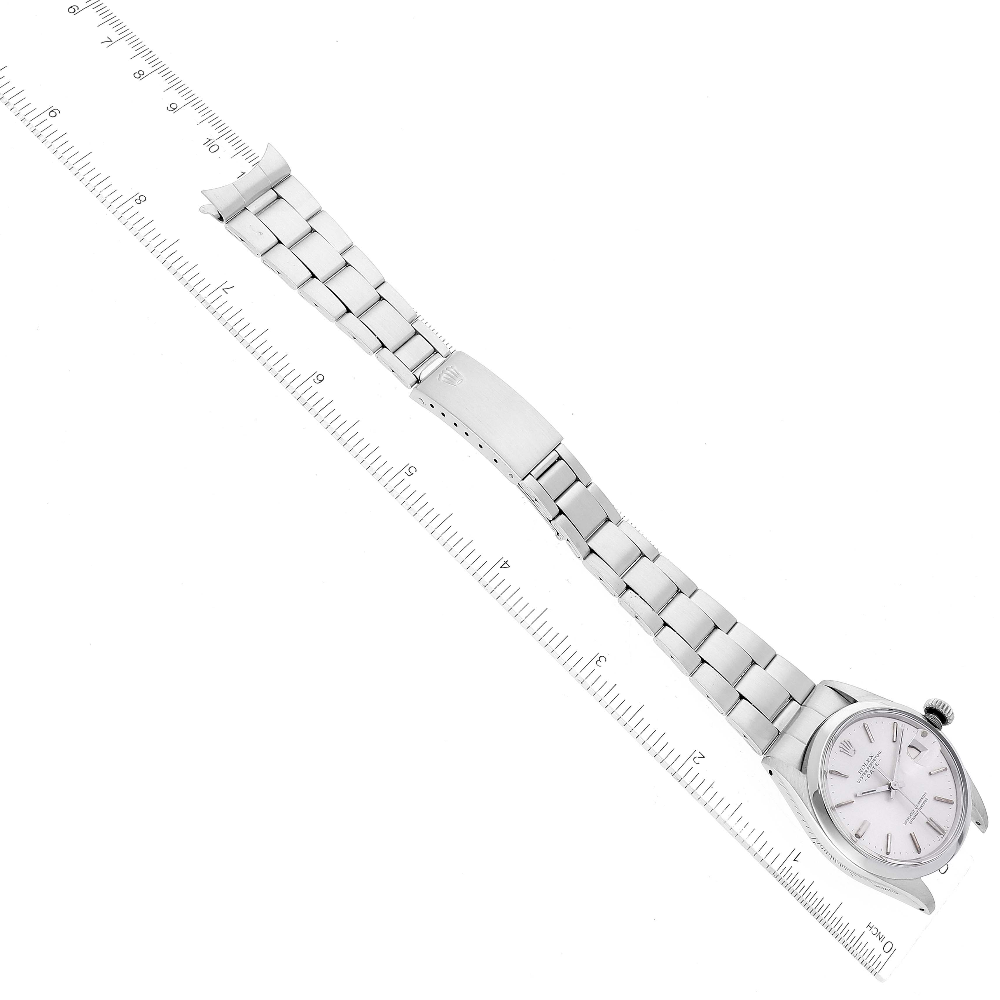 Aerial view of the Rolex Vintage Collection 1500 Men's Stainless Steel Silver Dial 1500 Men's Stainless Steel Silver Dial watch showing the entire bracelet, clasp, and face, next to a ruler for scale.