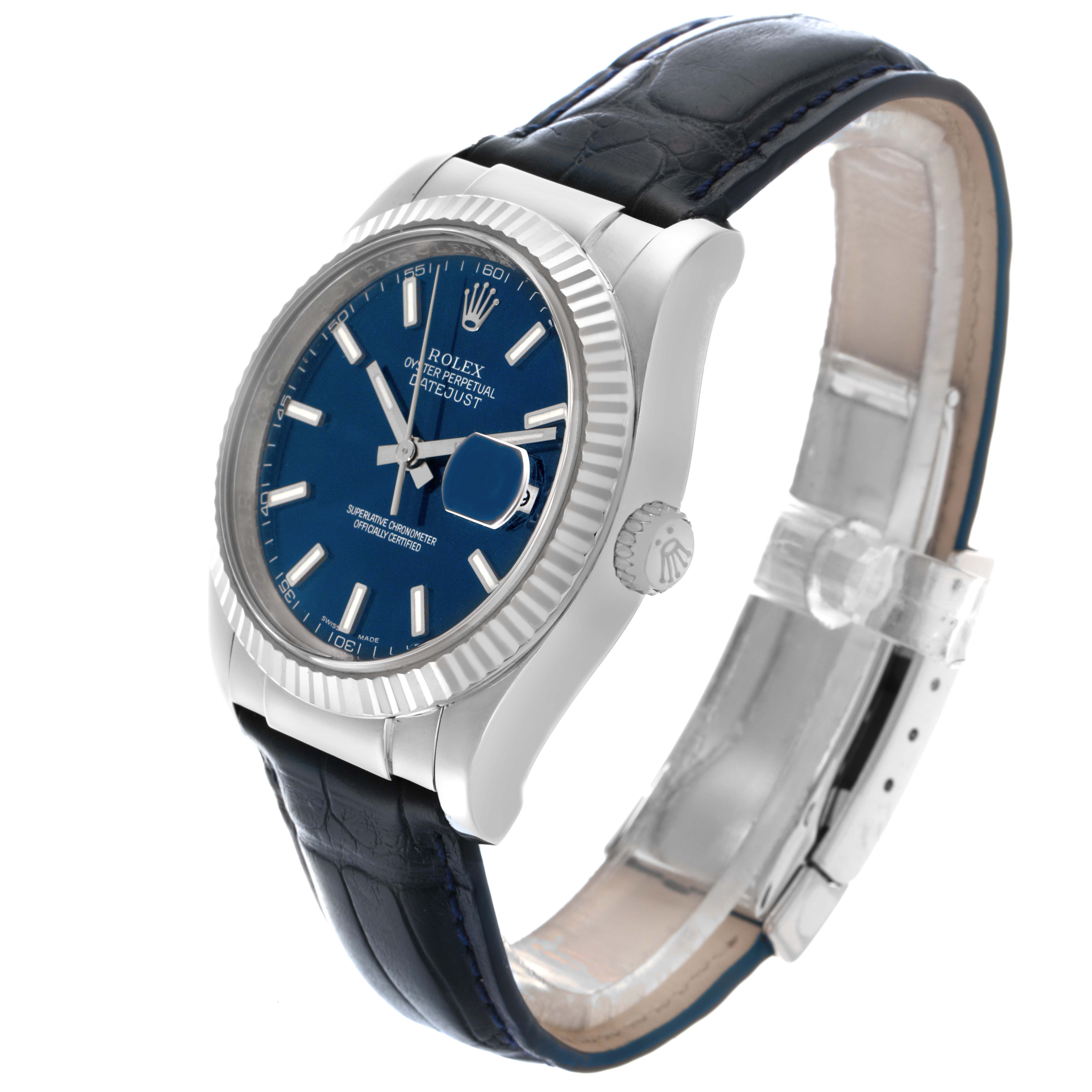The Rolex Datejust 116139 Men
s White Gold Blue Dial 116139 Men
s White Gold Blue Dial watch is shown at a tilted angle displaying the face, bezel, crown, and leather strap.